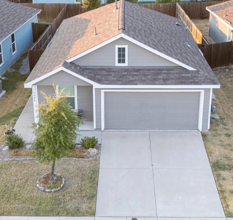 Gray exterior with white trim, a two-car garage, and a concrete driveway