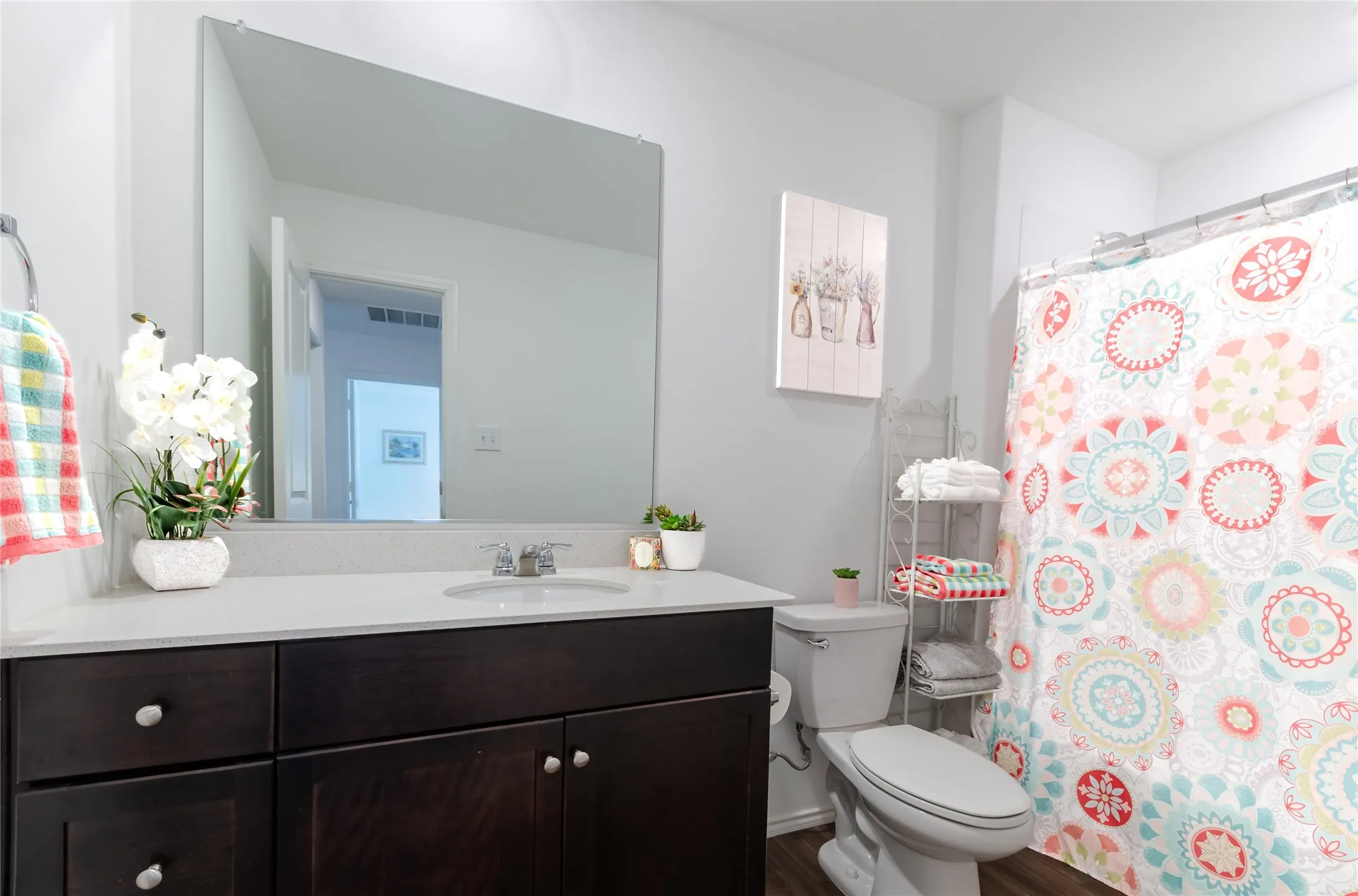 Vanity with dark wood cabinetry, white countertop, and integrated sink