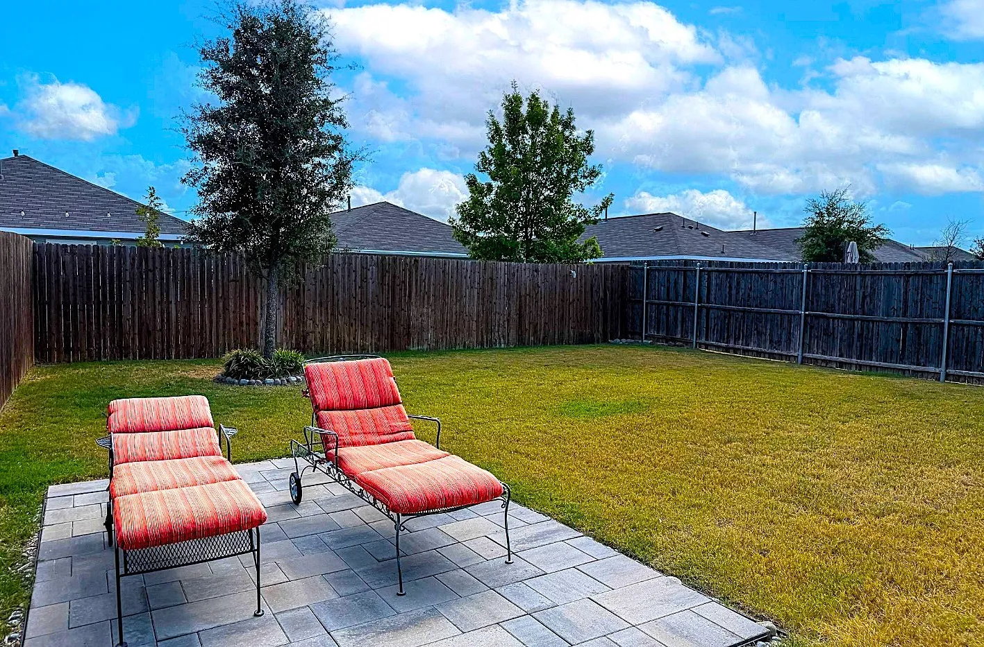 Expansive backyard featuring a paver patio, wood privacy fencing, and a generous lawn​​‌​​​​‌​​‌‌​‌‌​​​‌‌​‌​‌​‌​​​‌​​ area