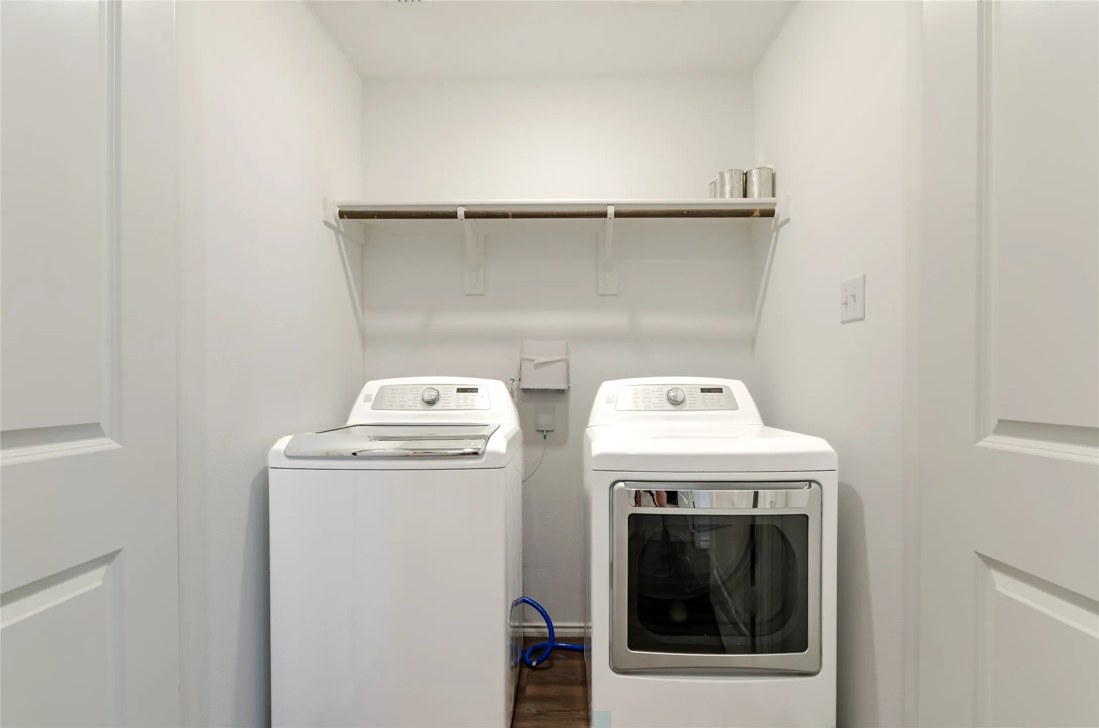 Compact laundry area with a white shelving unit