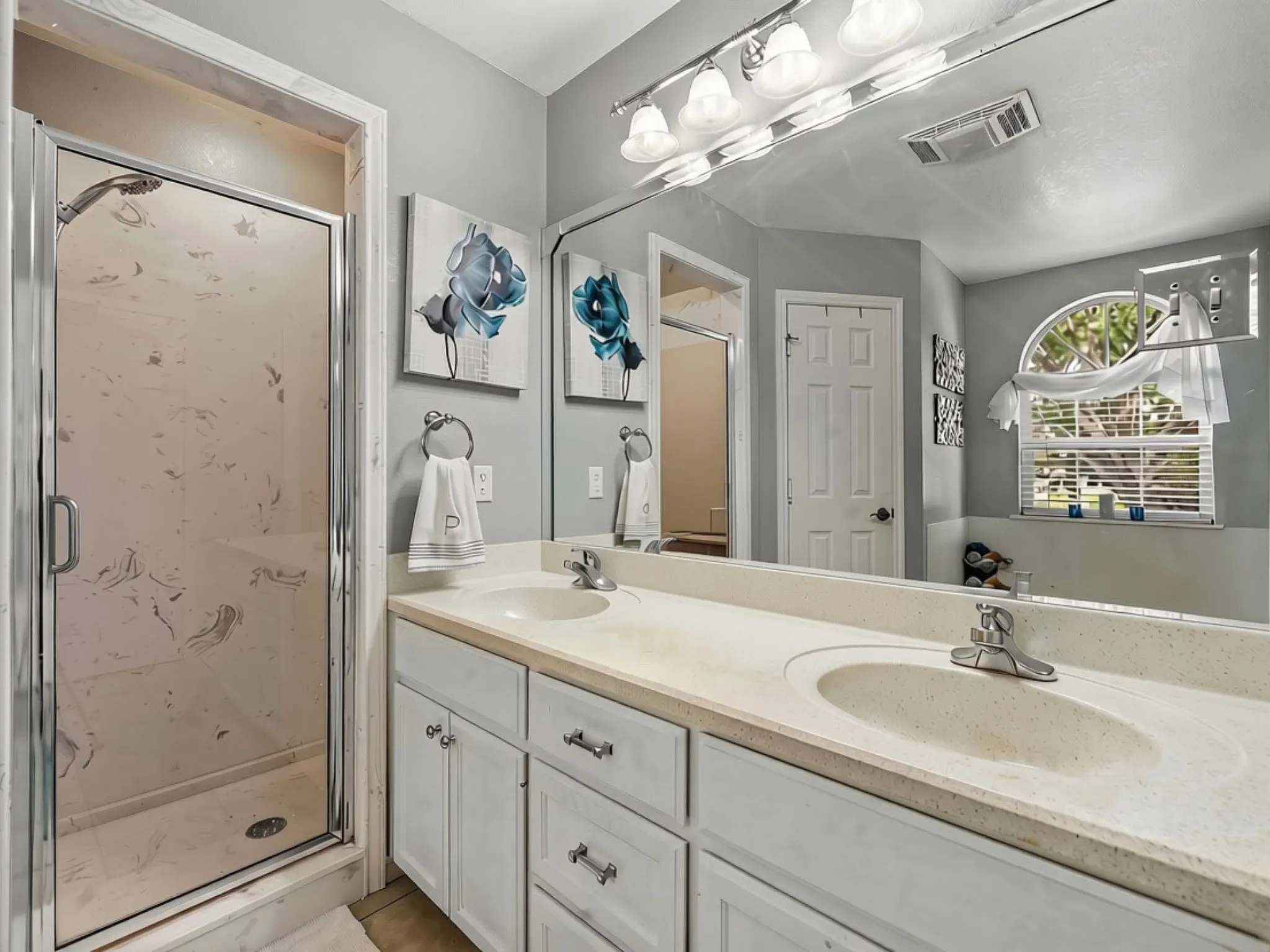 Dual vanity with integrated sinks, white cabinetry, and a full-width mirror