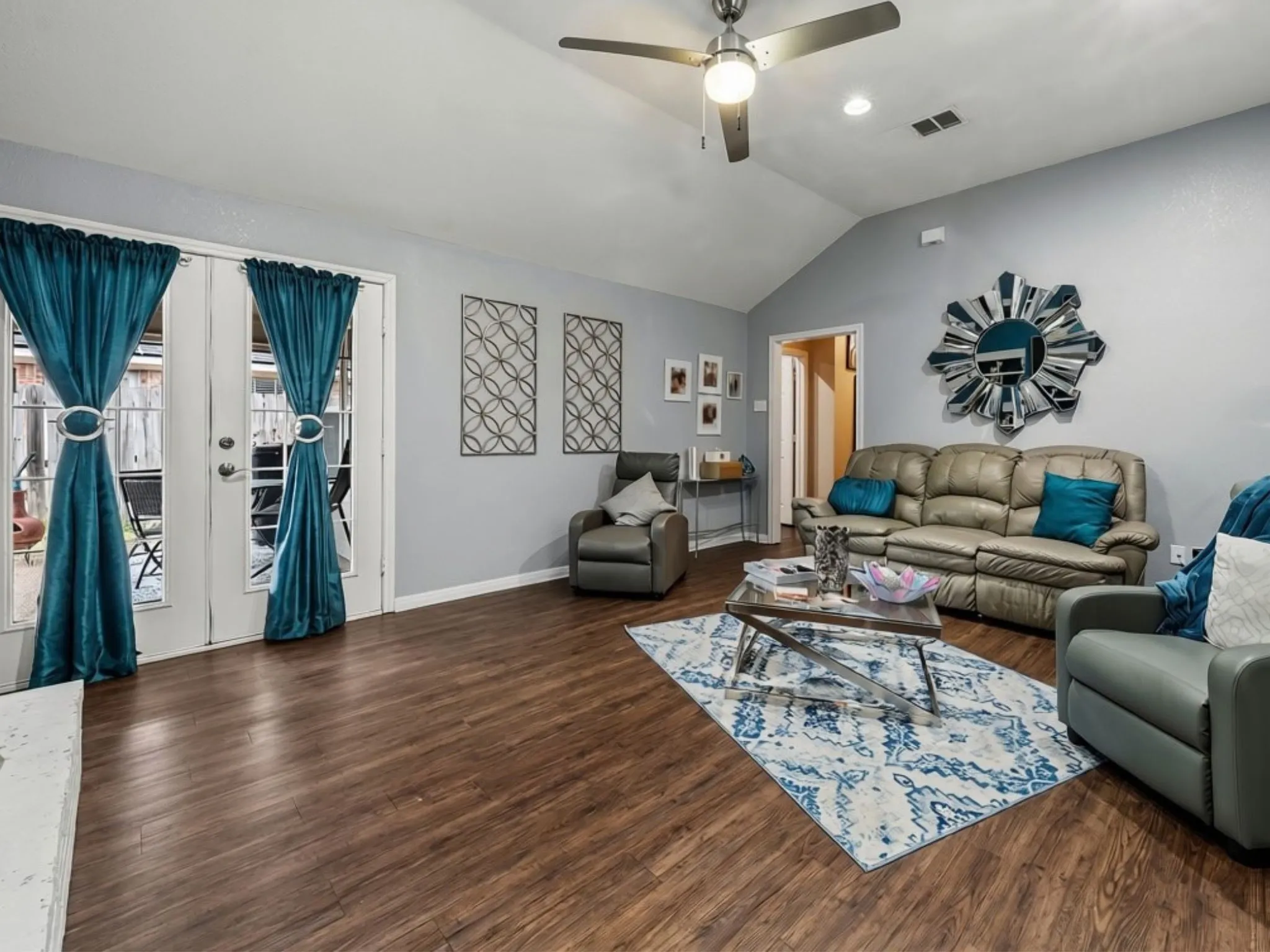 Vaulted ceiling with a ceiling fan, wood-finish flooring, recessed lighting, and double glass-paneled doors