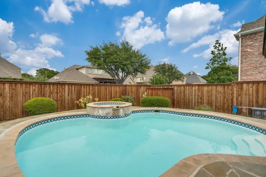 Backyard oasis featuring a swimming pool, integrated spa, and flagstone coping