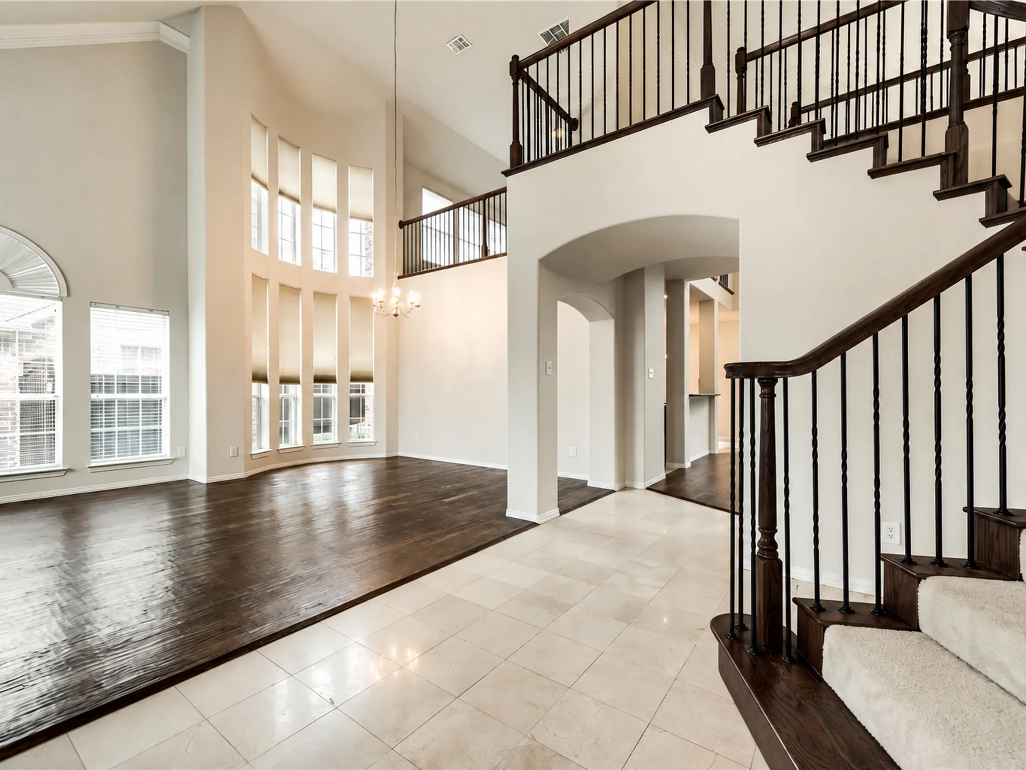 Two-story foyer with a grand staircase and wrought iron balusters