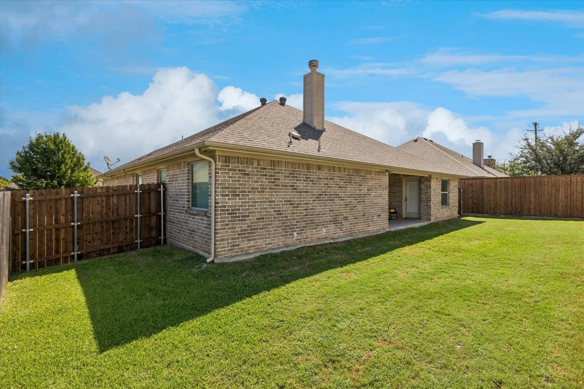 Brick exterior, covered patio, private fenced backyard, ample green space, and chimney feature