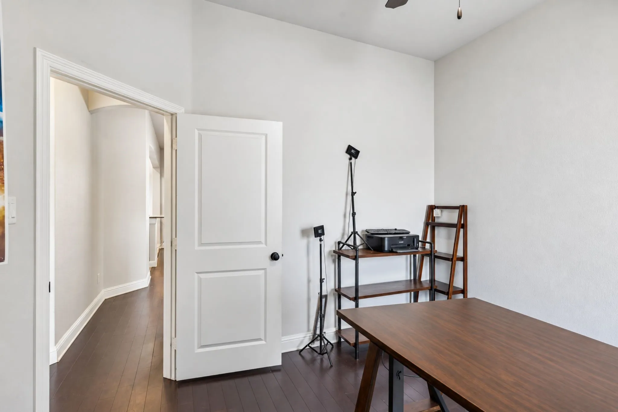 Wood-finish flooring with white walls and a two-panel interior door