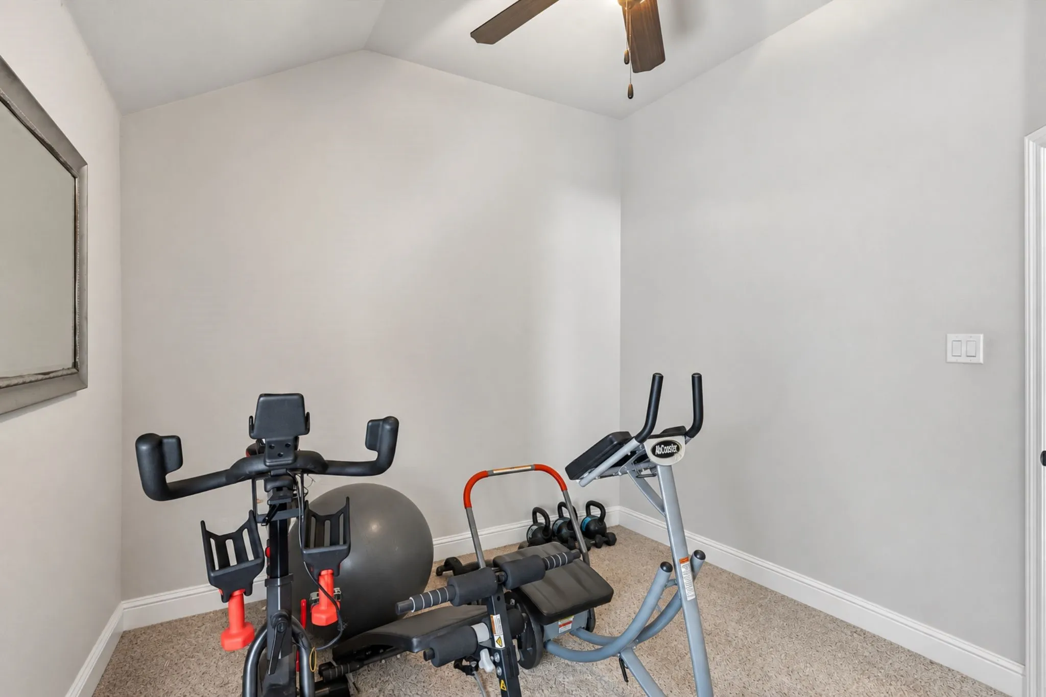 Vaulted ceiling with a ceiling fan, neutral wall paint, and carpeted flooring