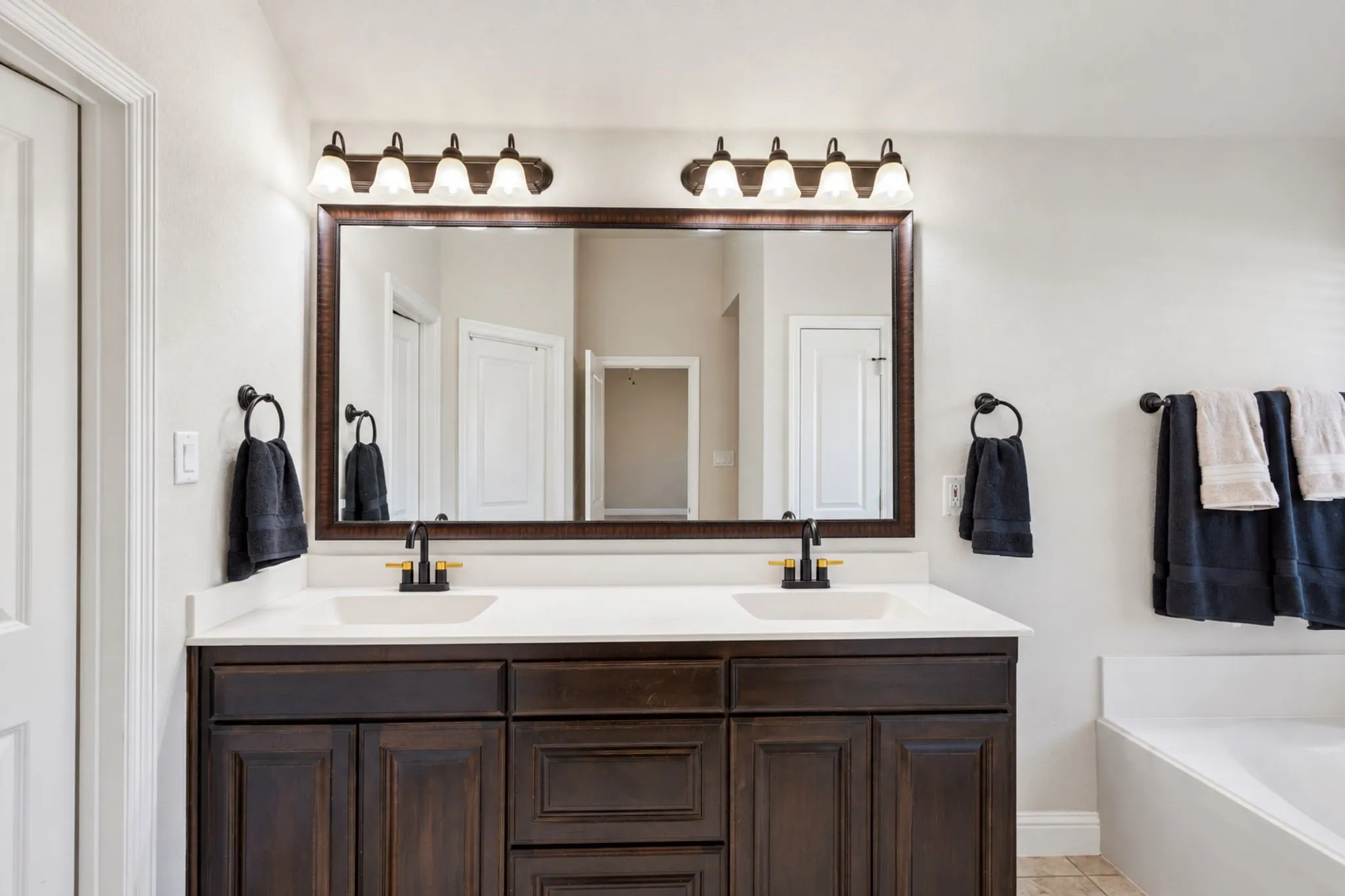 Dual vanity with a dark wood-finish cabinet, white countertop, and rectangular undermount sinks