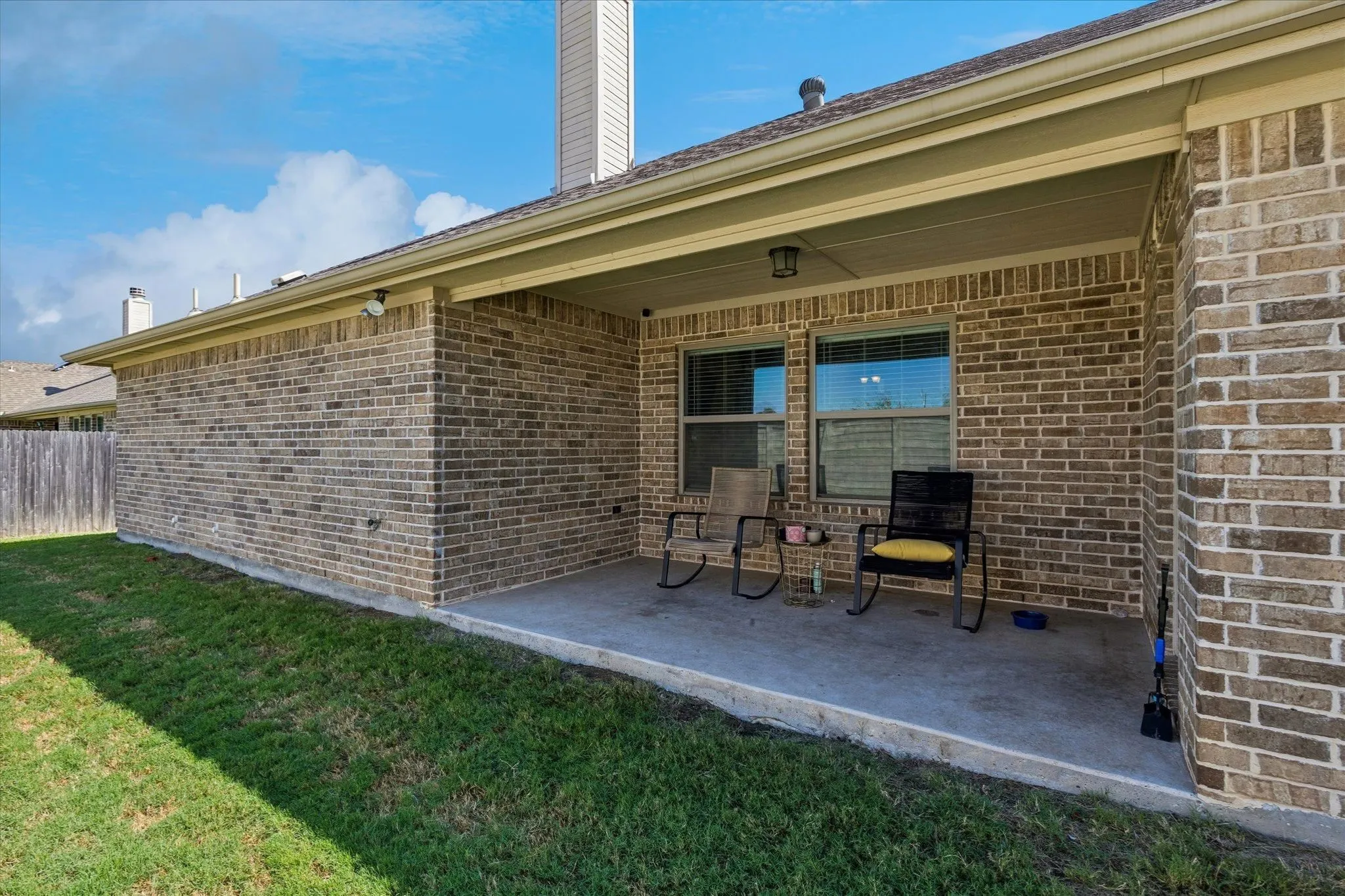 Covered patio with a concrete slab, brick exterior, and recessed lighting