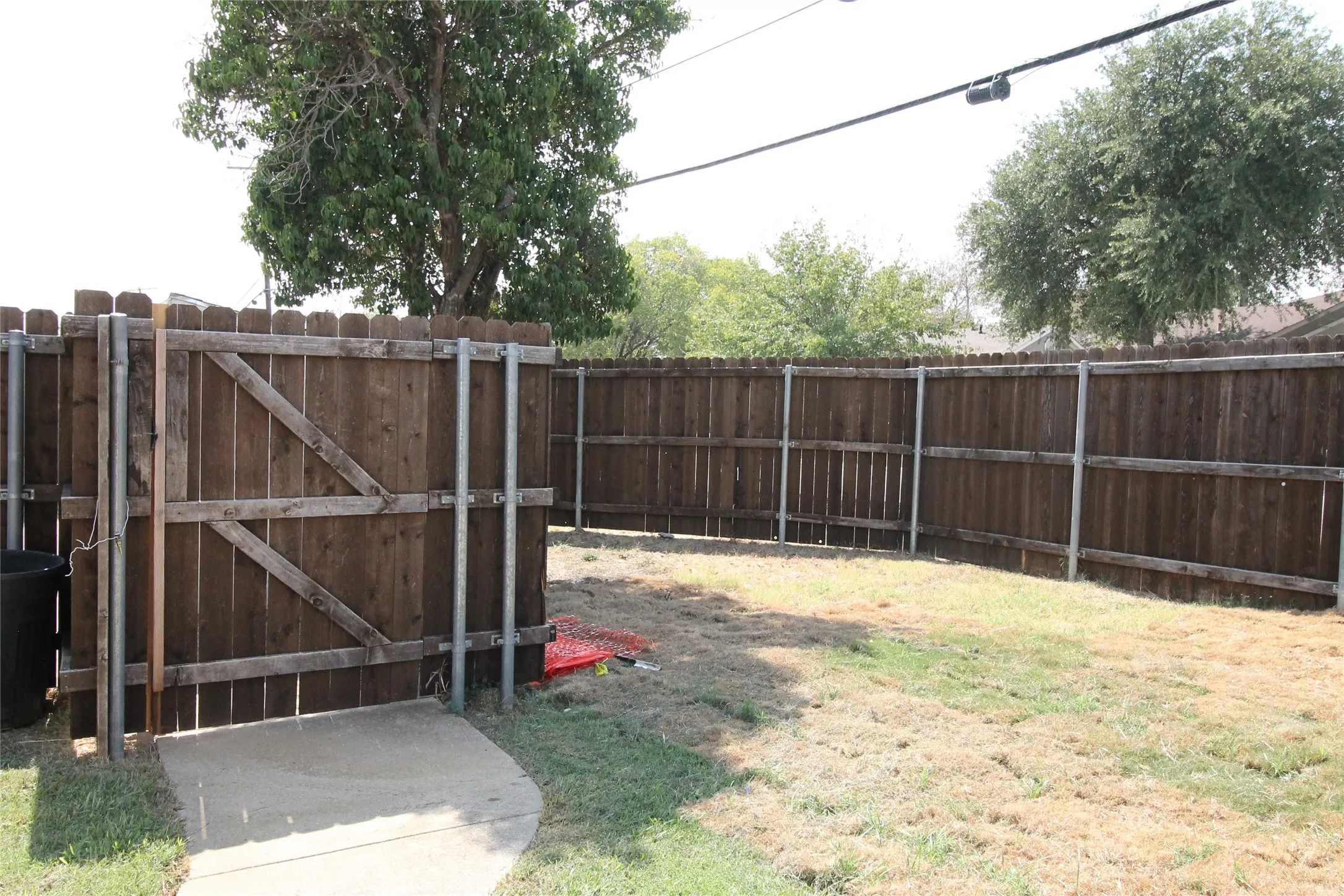Wood privacy fence with metal posts and a wooden gate
