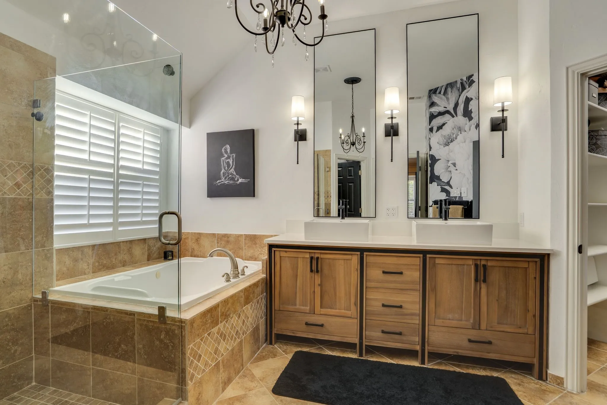 Dual vessel sinks, wood-finish cabinetry, built-in bathtub, glass-enclosed shower, and tile flooring