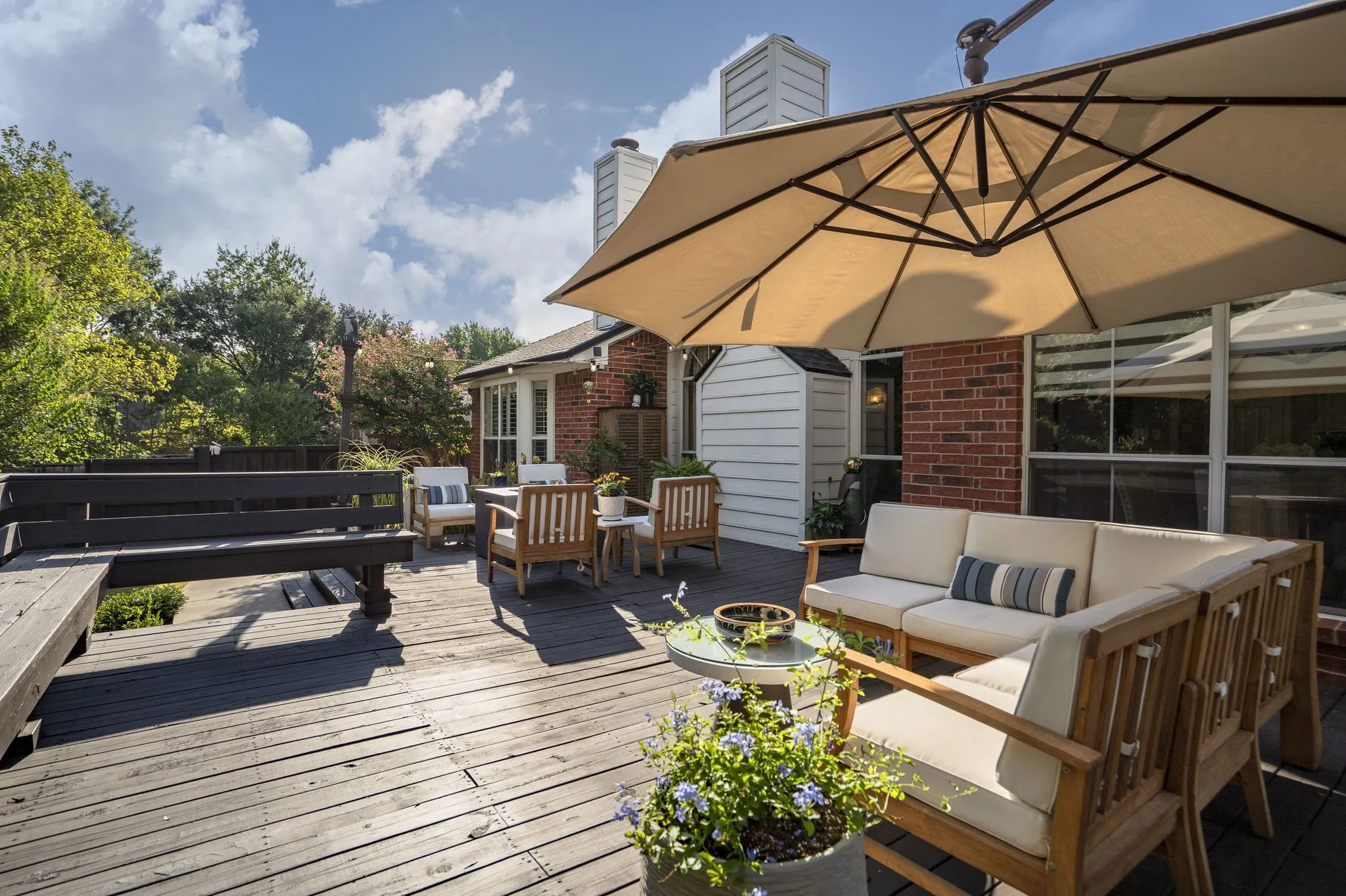 Expansive wooden deck with a built-in bench, offering ample outdoor living space