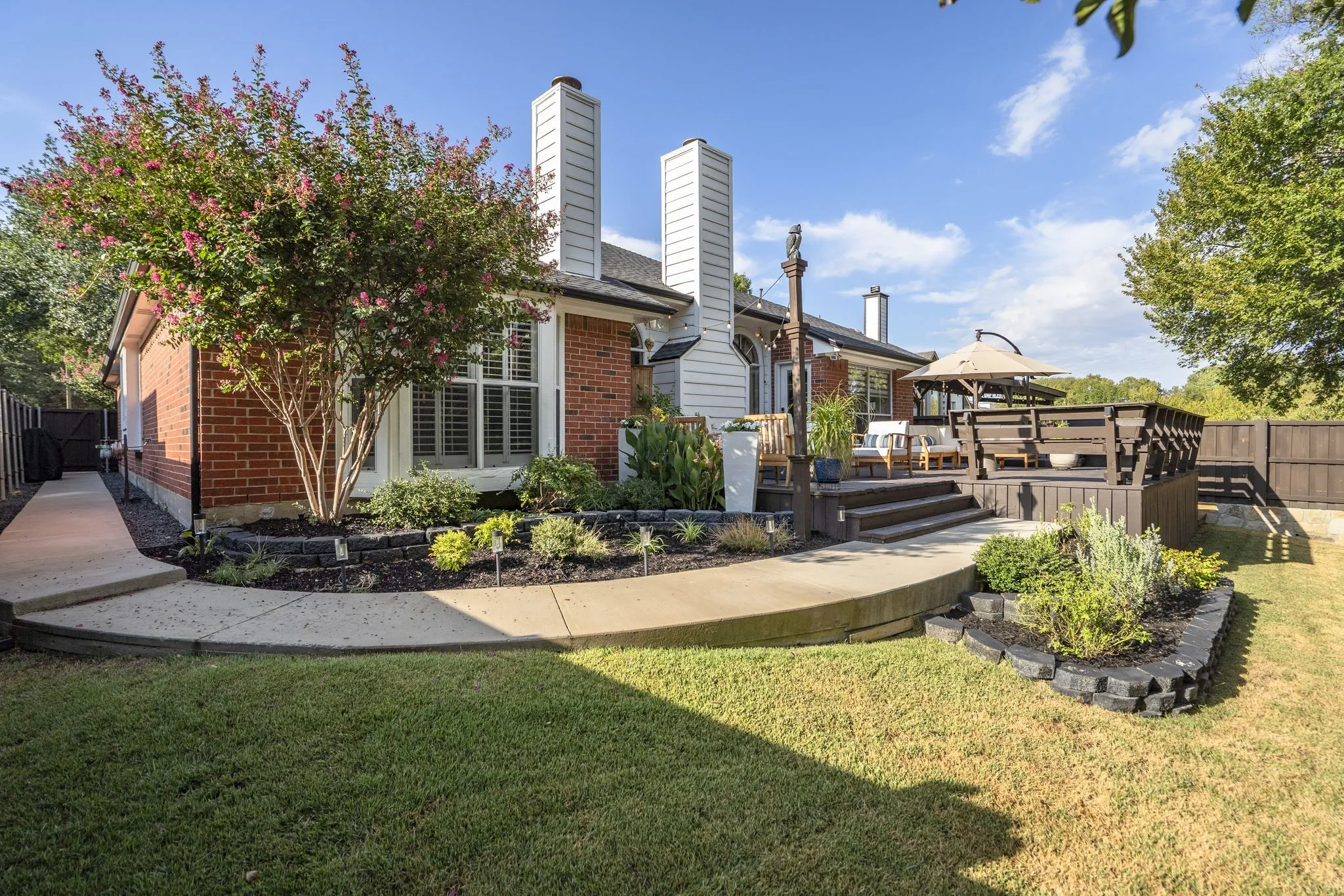 Brick exterior with multiple chimneys, featuring a multilevel wood deck