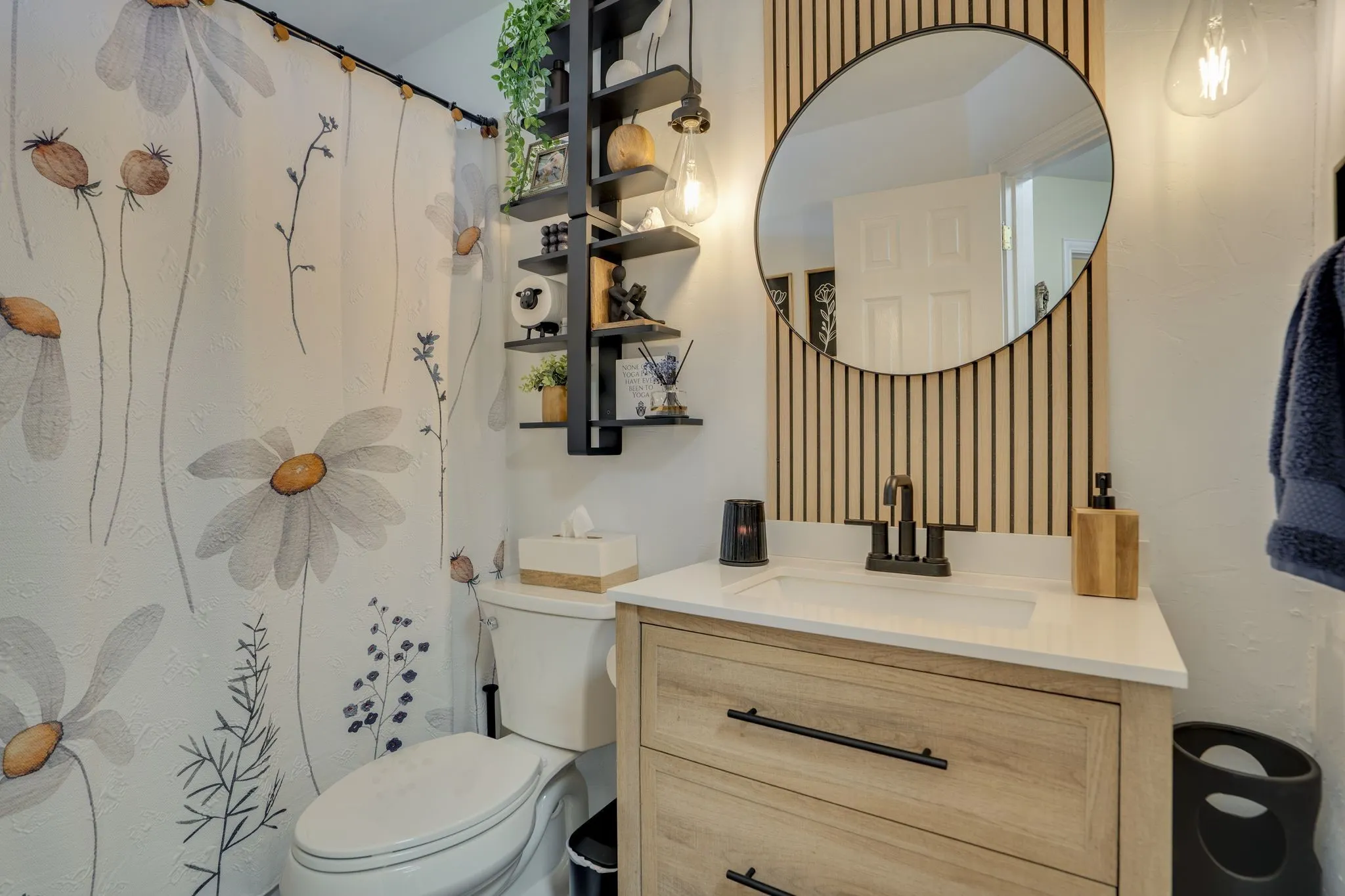 White vanity with a neutral-toned countertop and matte black hardware