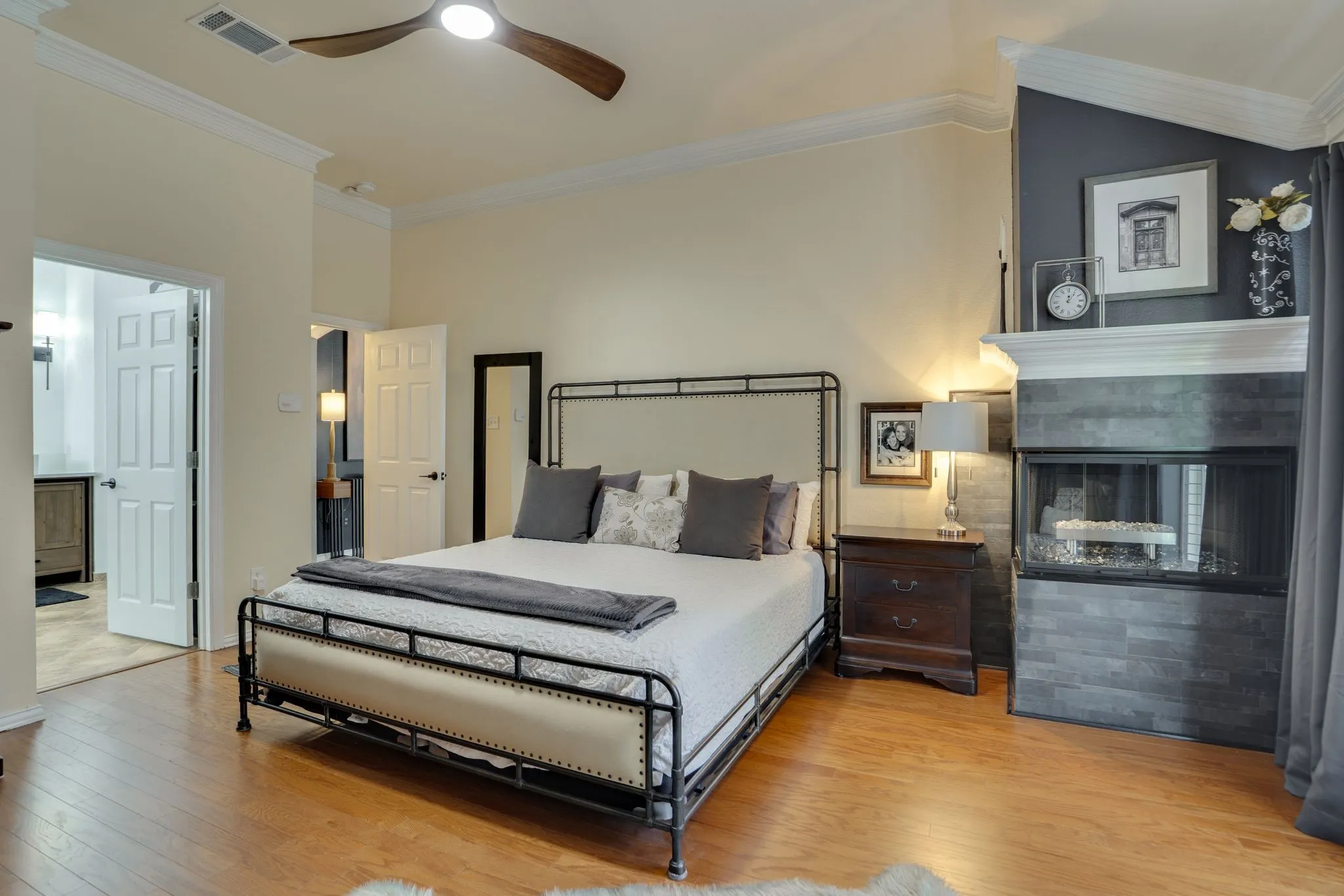 Wood-finish flooring, crown molding, and a modern ceiling fan