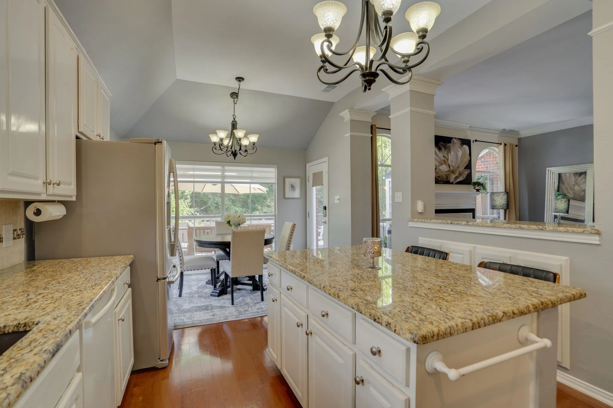 Kitchen with white cabinetry, granite countertops, and a central island