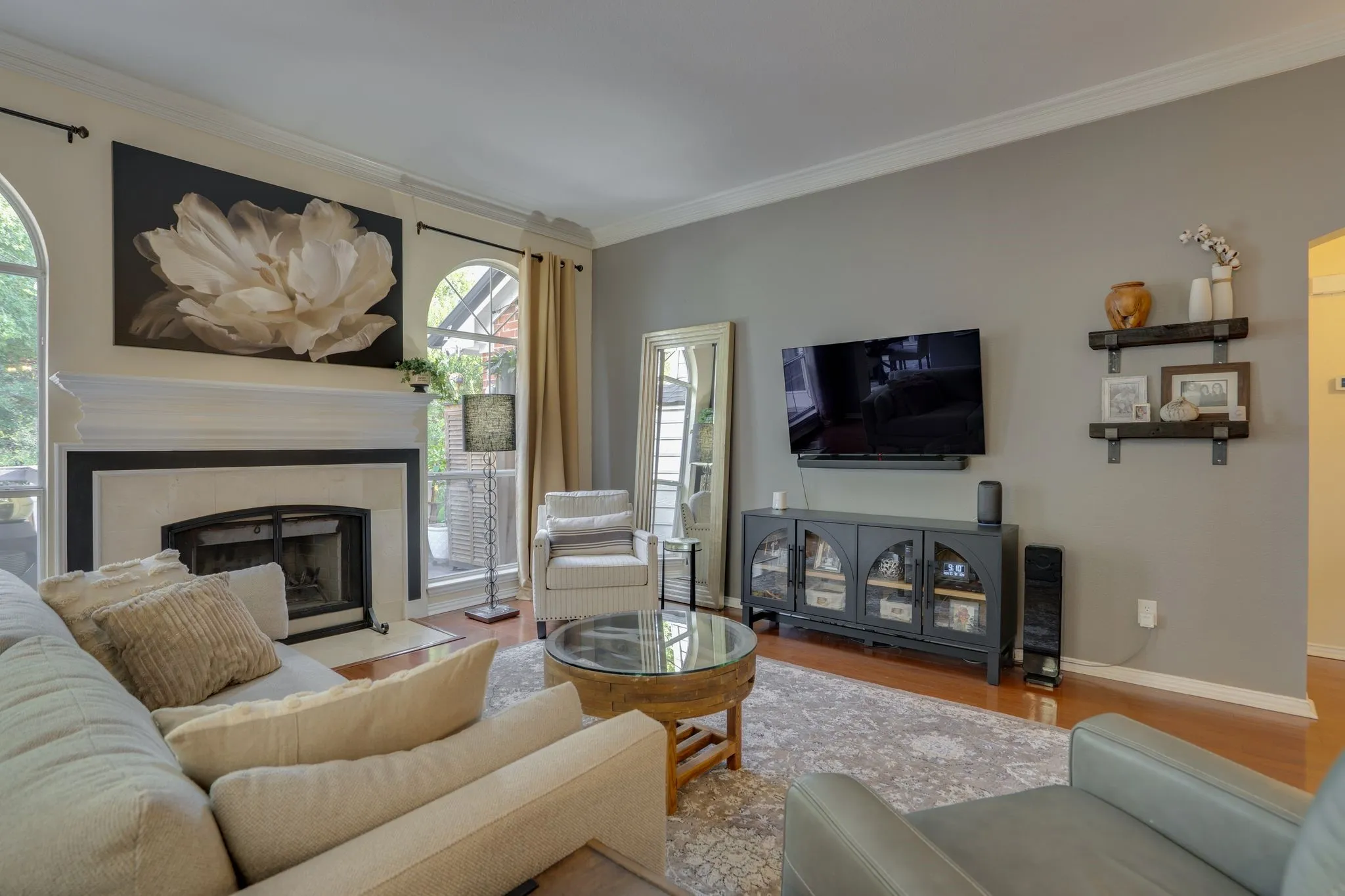 Hardwood flooring, arched windows, built-in fireplace, crown molding, and a built-in media console