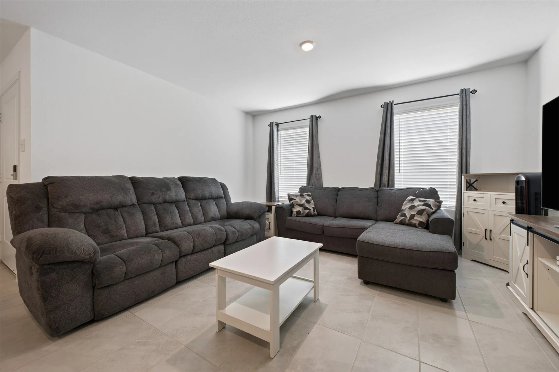 Tiled flooring in a bright interior space with recessed lighting