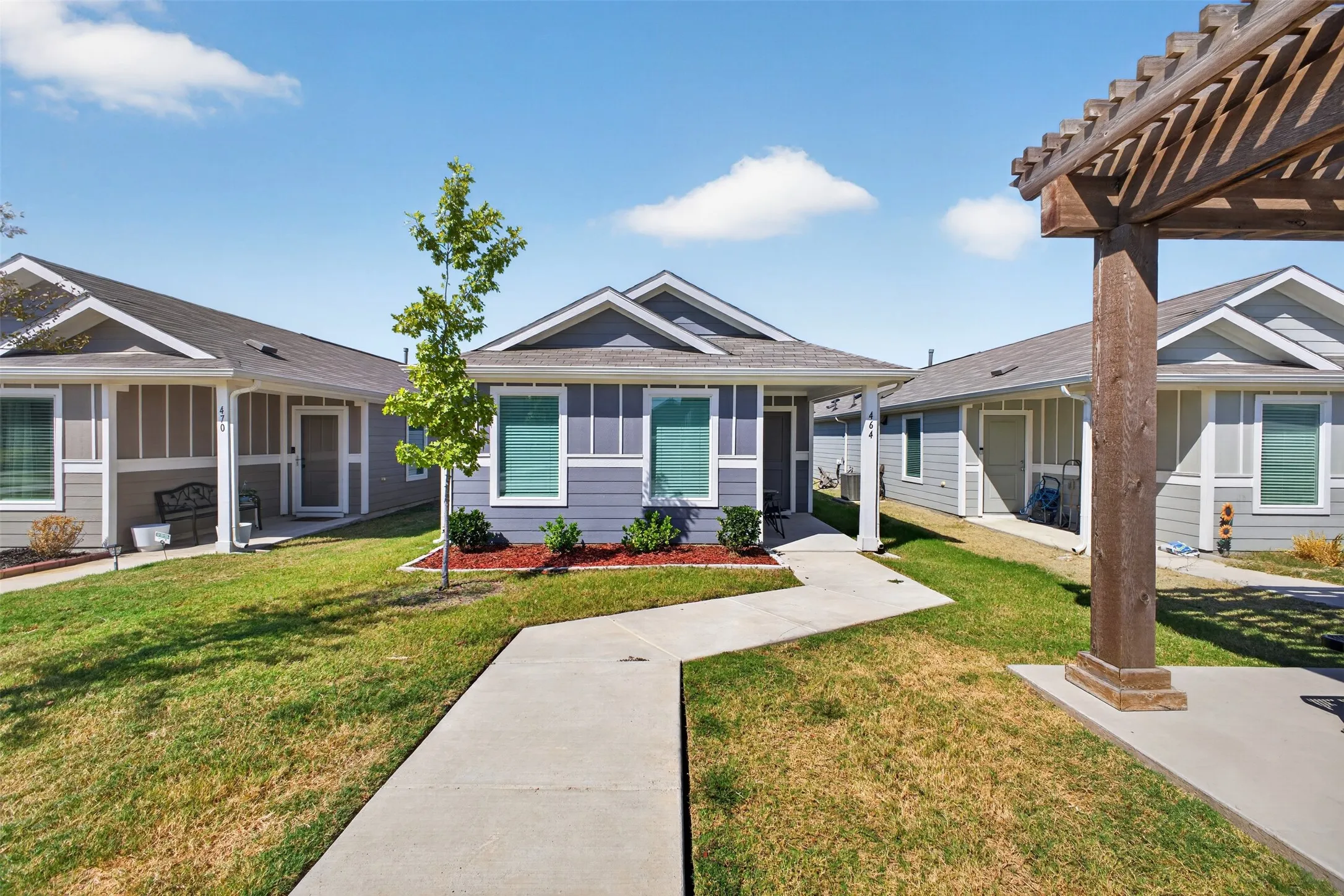 Contemporary exterior with blue horizontal siding, white trim, a covered entry, and a concrete walkway
