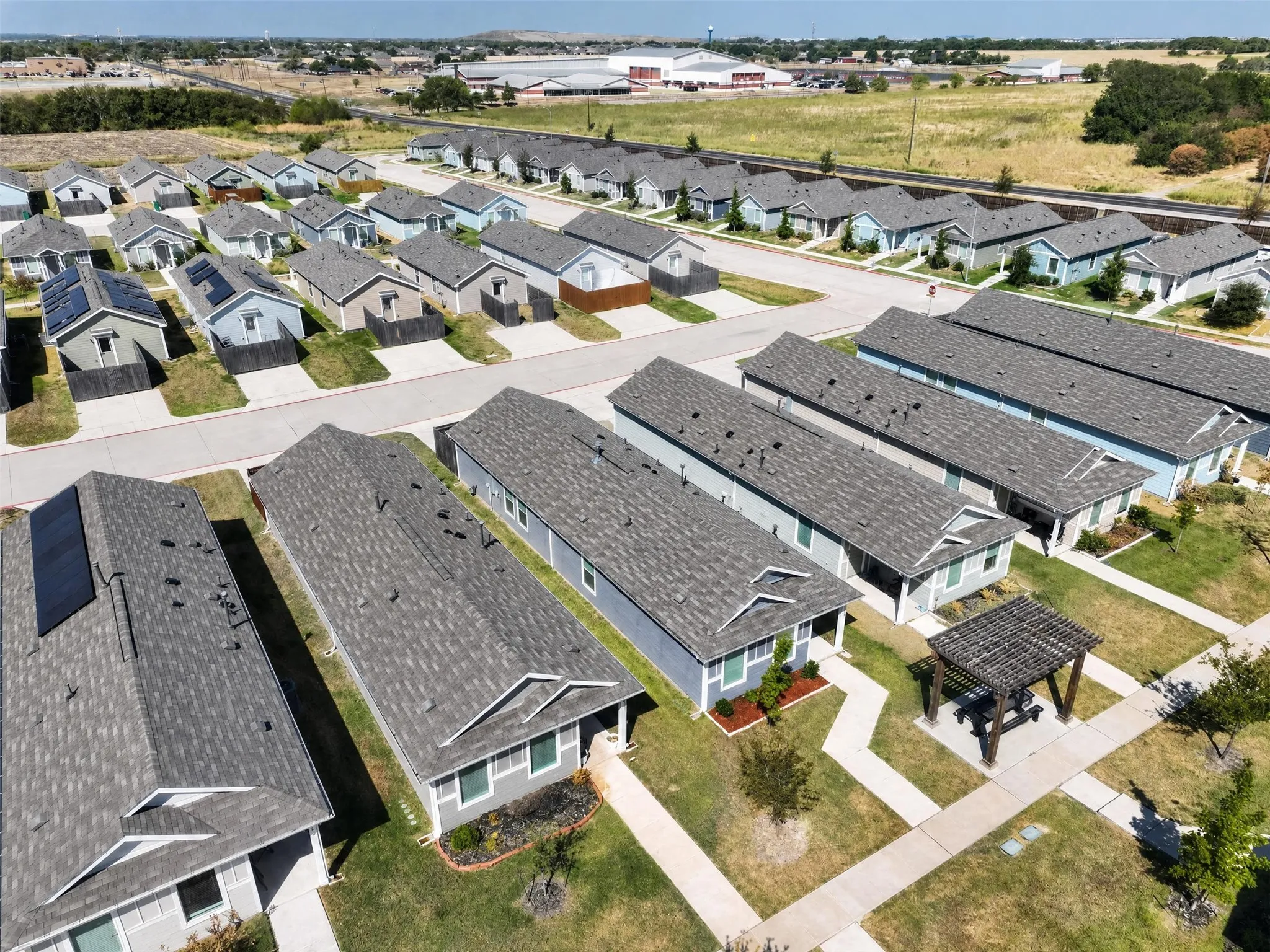 Community setting featuring numerous single-story residences, shingled roofs, and varied exterior siding