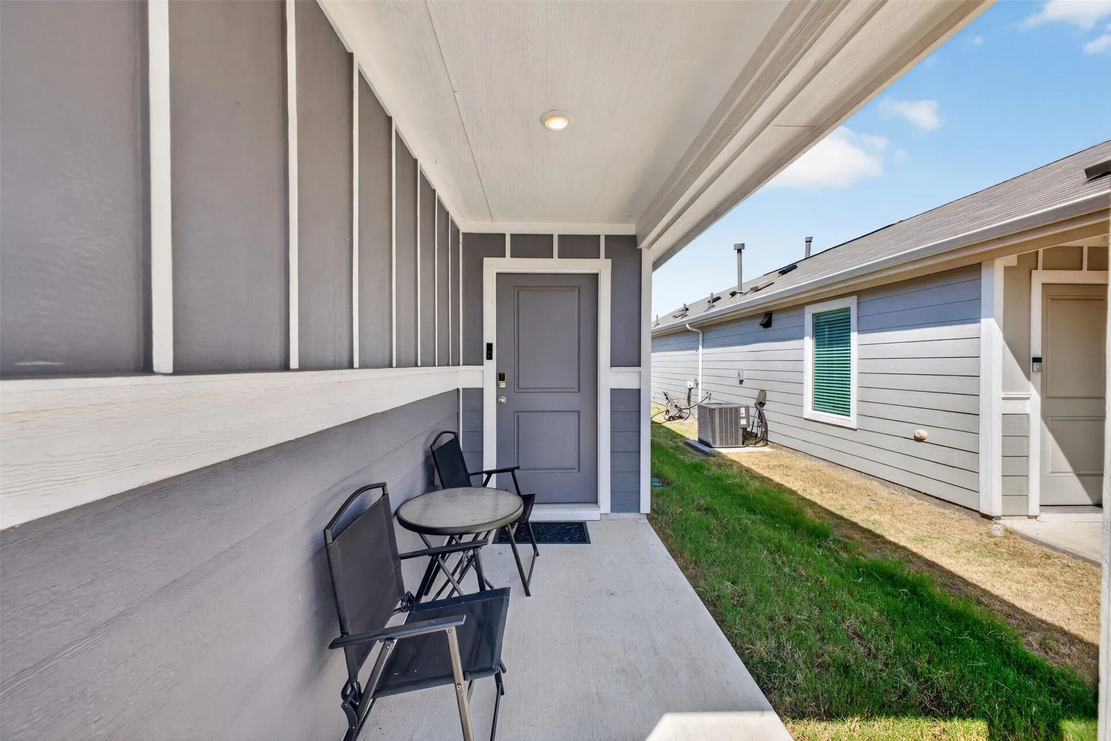 Covered concrete patio with a recessed ceiling light and painted siding