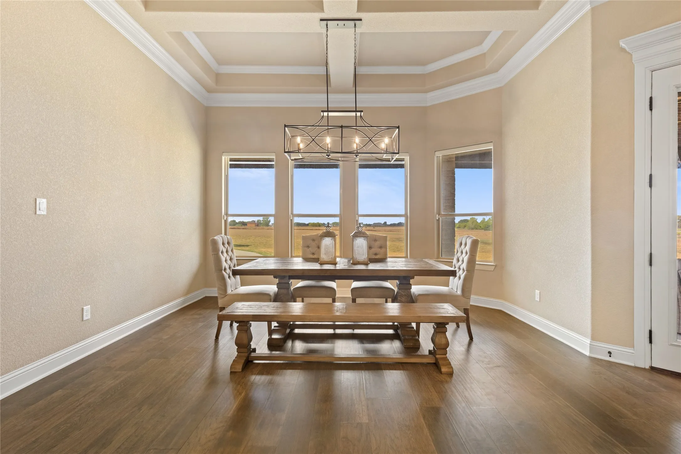 Hardwood-style flooring throughout with a coffered ceiling and decorative crown molding