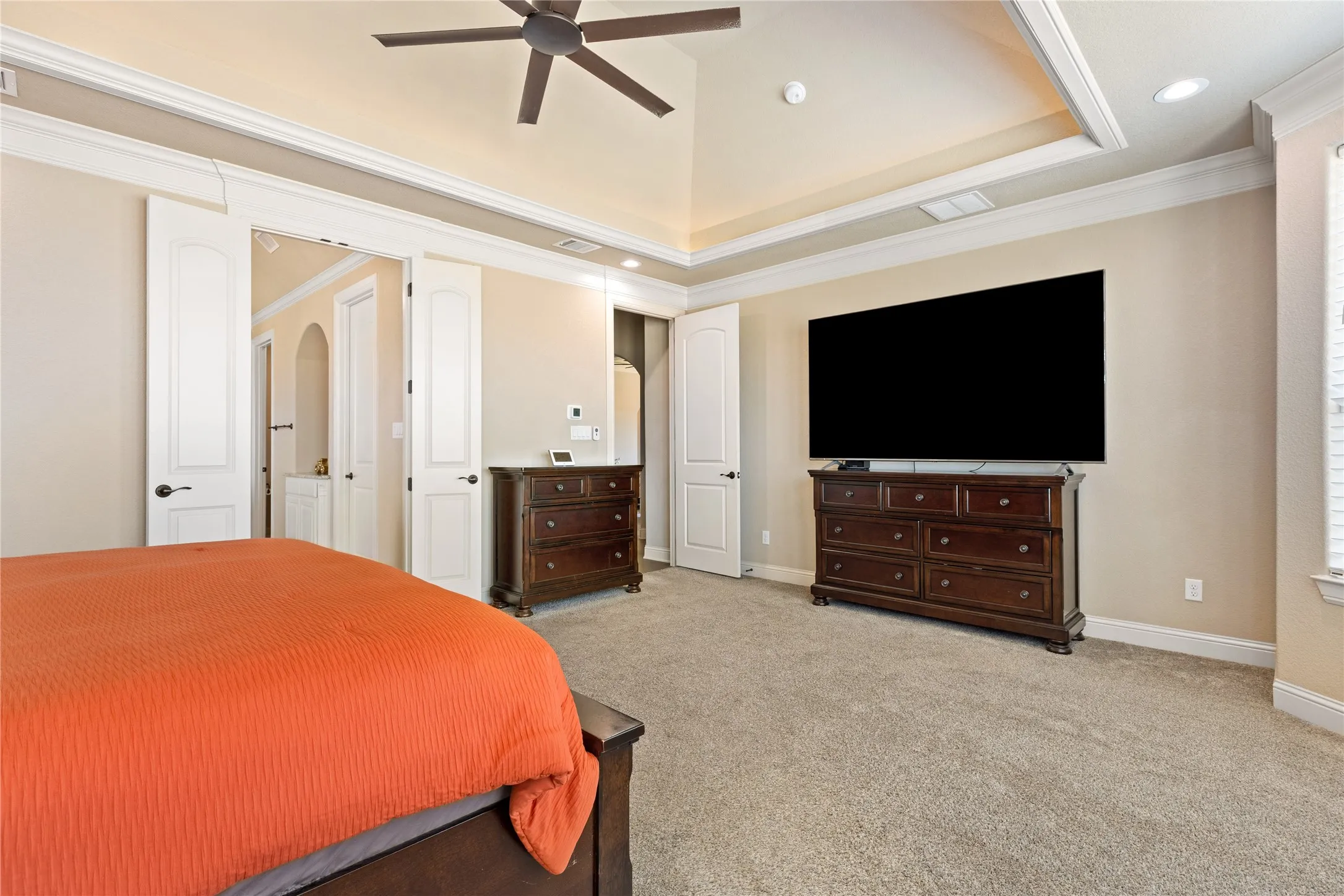 Recessed lighting, ceiling fan, tray ceiling, carpeted flooring, and white trim