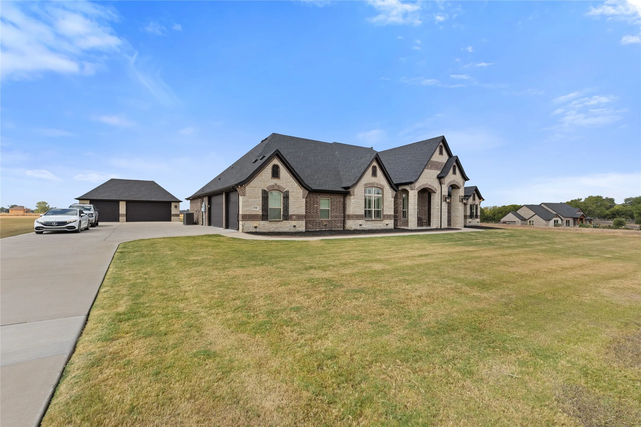 Brick and stone exterior with dark roofing