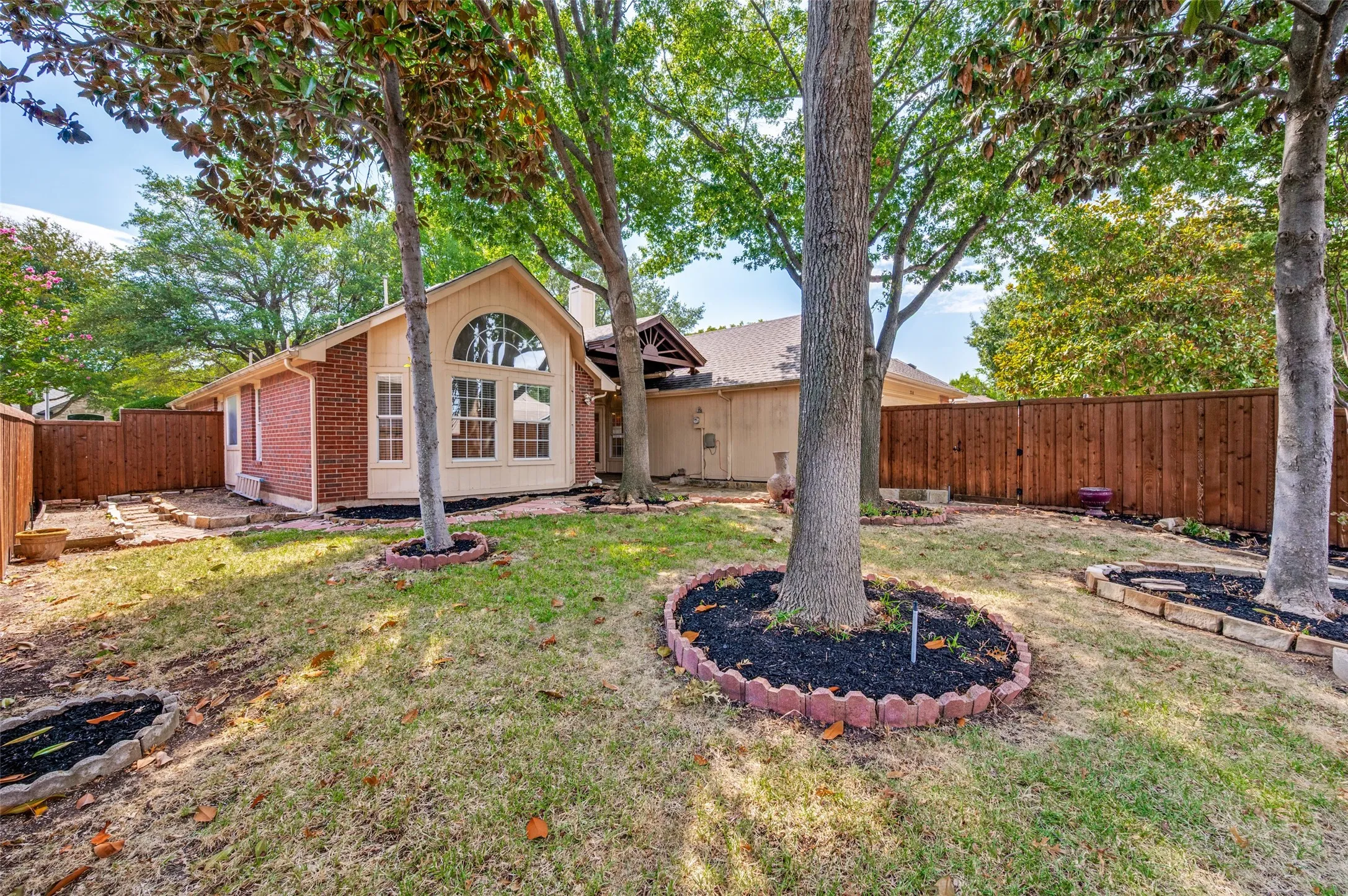 Private backyard with extended patio & mature trees