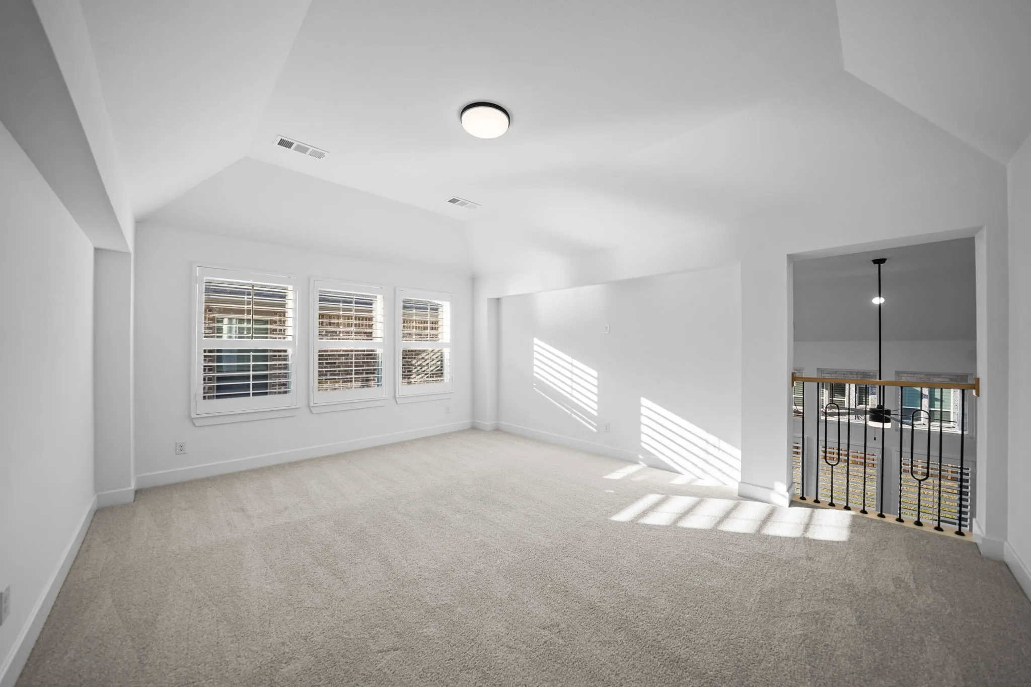 Expansive carpeted area with a vaulted ceiling
