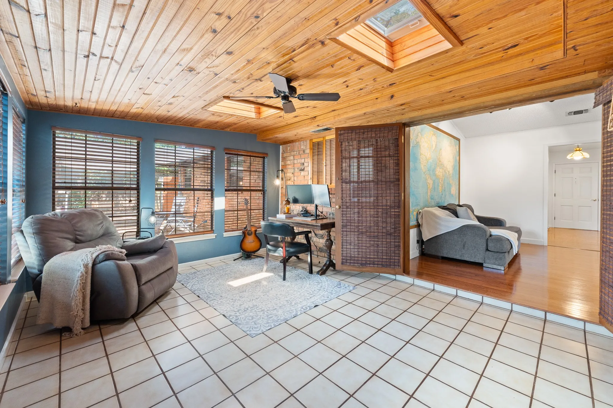 Wood-paneled ceiling with skylights and a ceiling fan