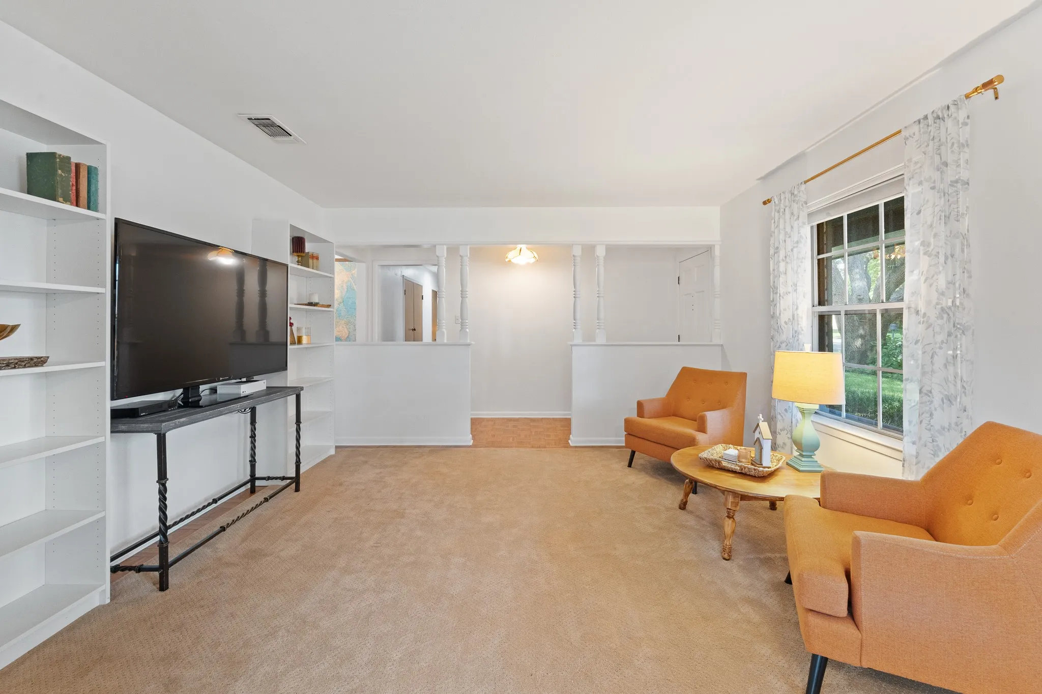 Built-in shelving, carpet flooring, and a large window