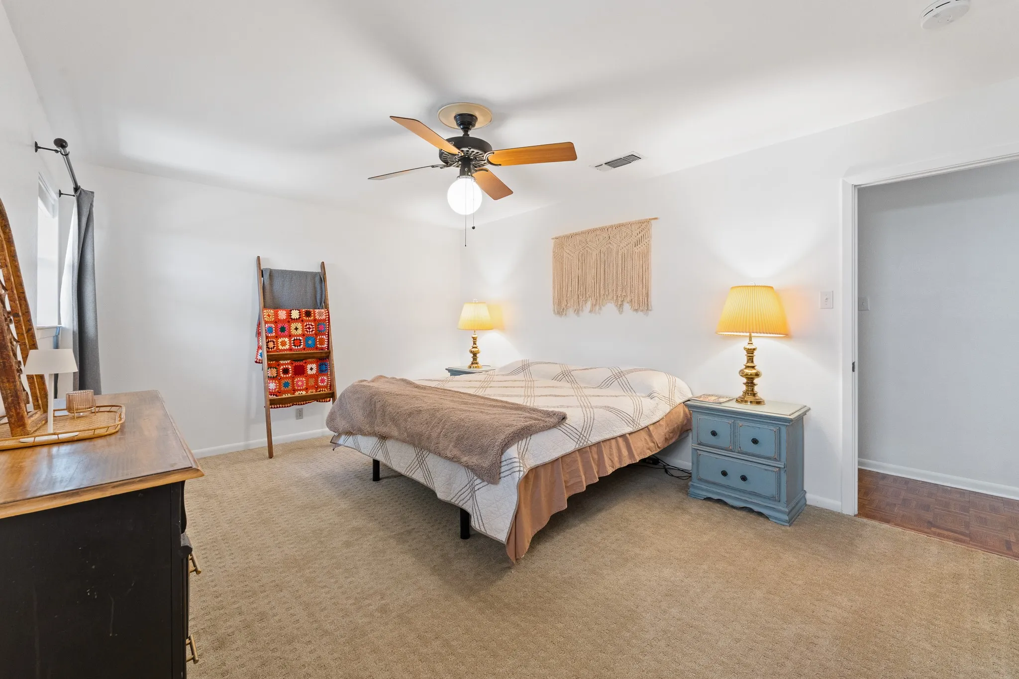 Carpeted flooring, ceiling fan with light fixture, and white painted walls