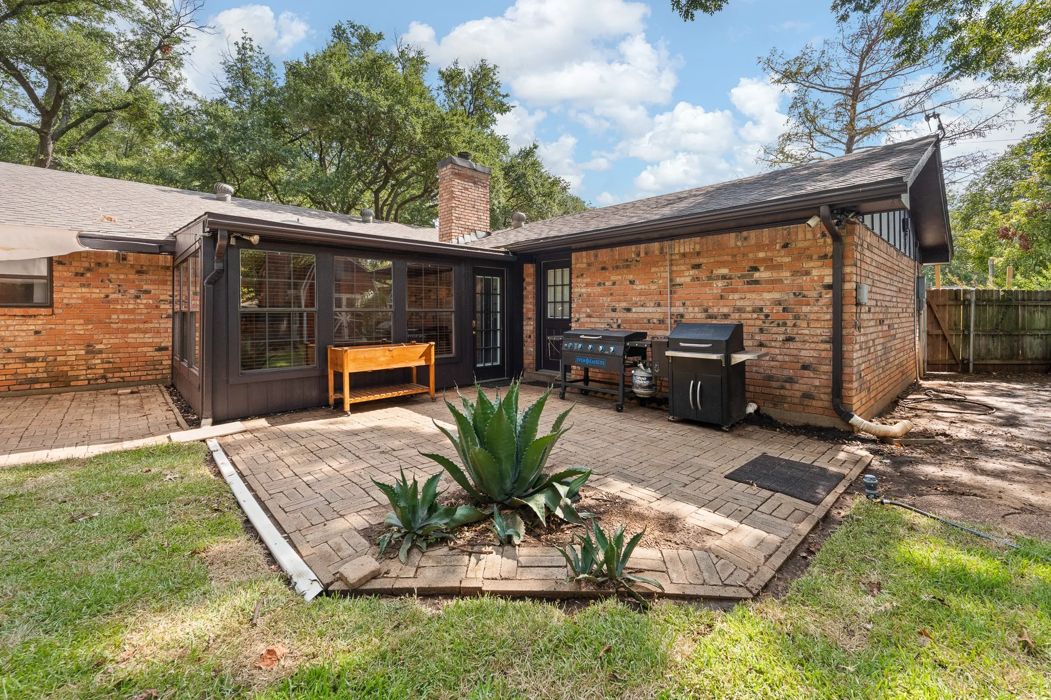 Brick exterior with dark trim and a shingled roof