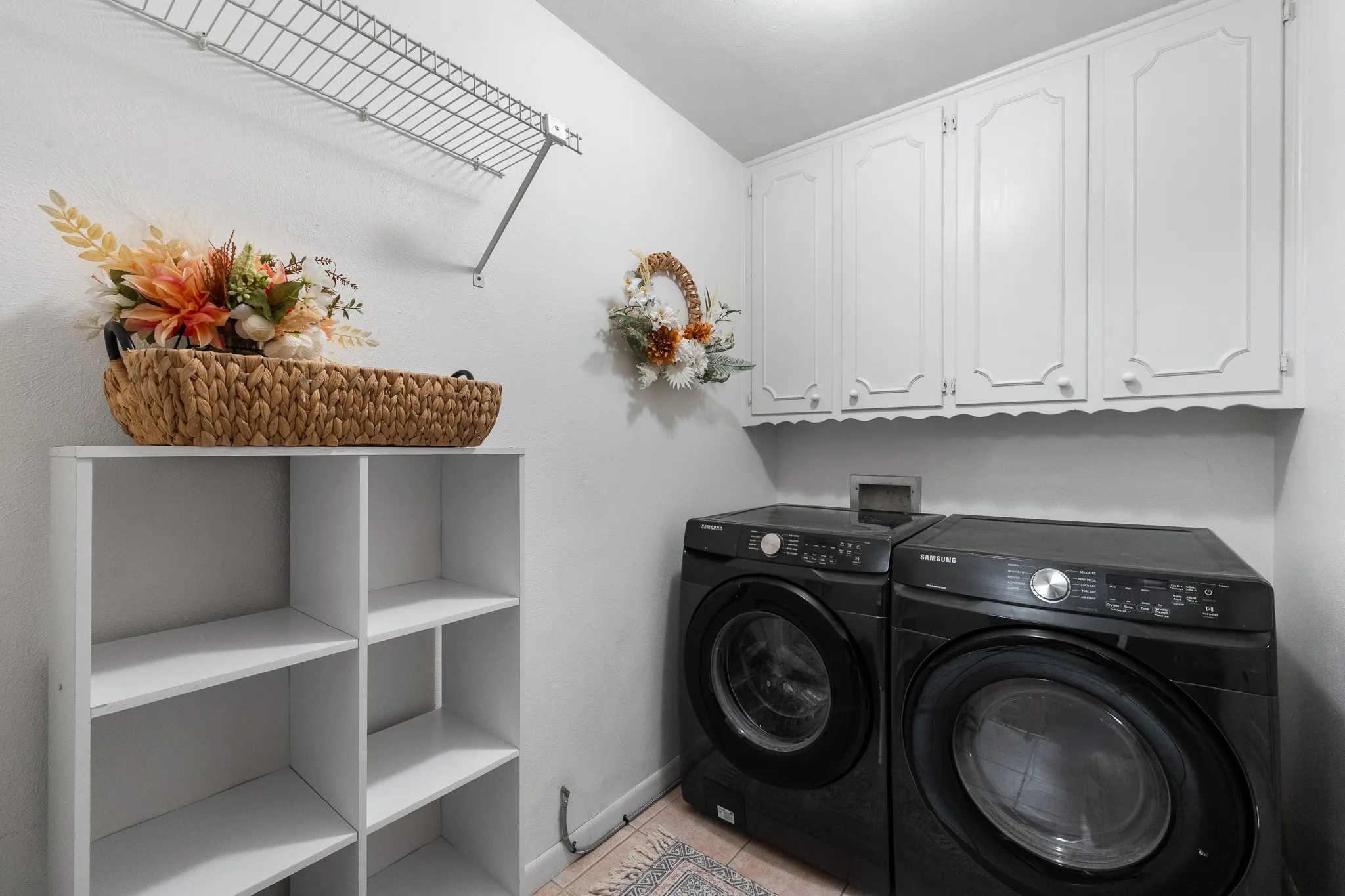 White upper cabinetry, open shelving, and a wire rack provide storage