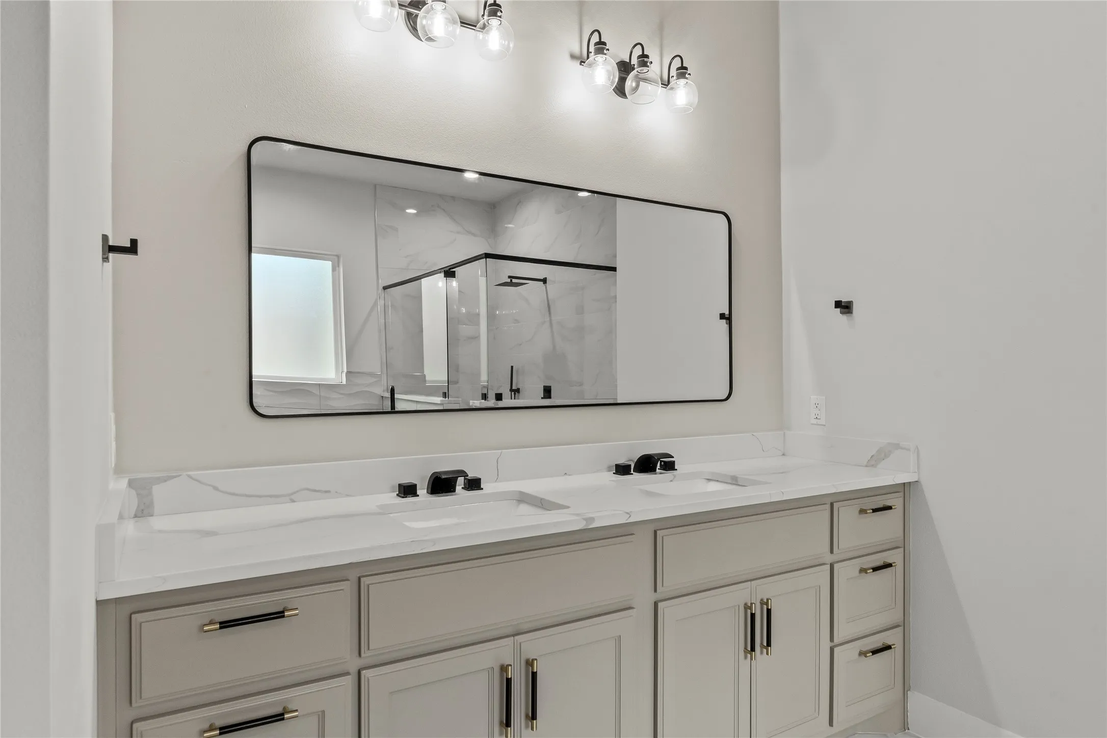 Dual vanity with white countertops, undermount sinks, and matte black fixtures