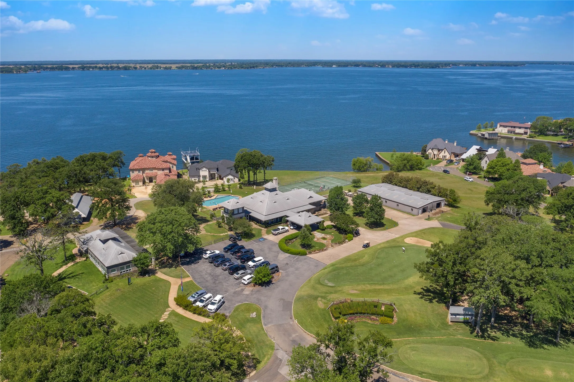 Expansive waterfront property featuring a large body of water, extensive green spaces, and multiple structures