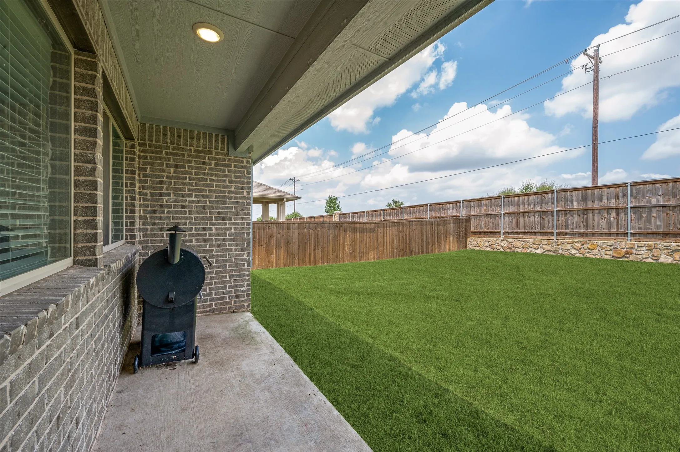 Covered patio with a concrete surface, recessed lighting, and brick exterior walls