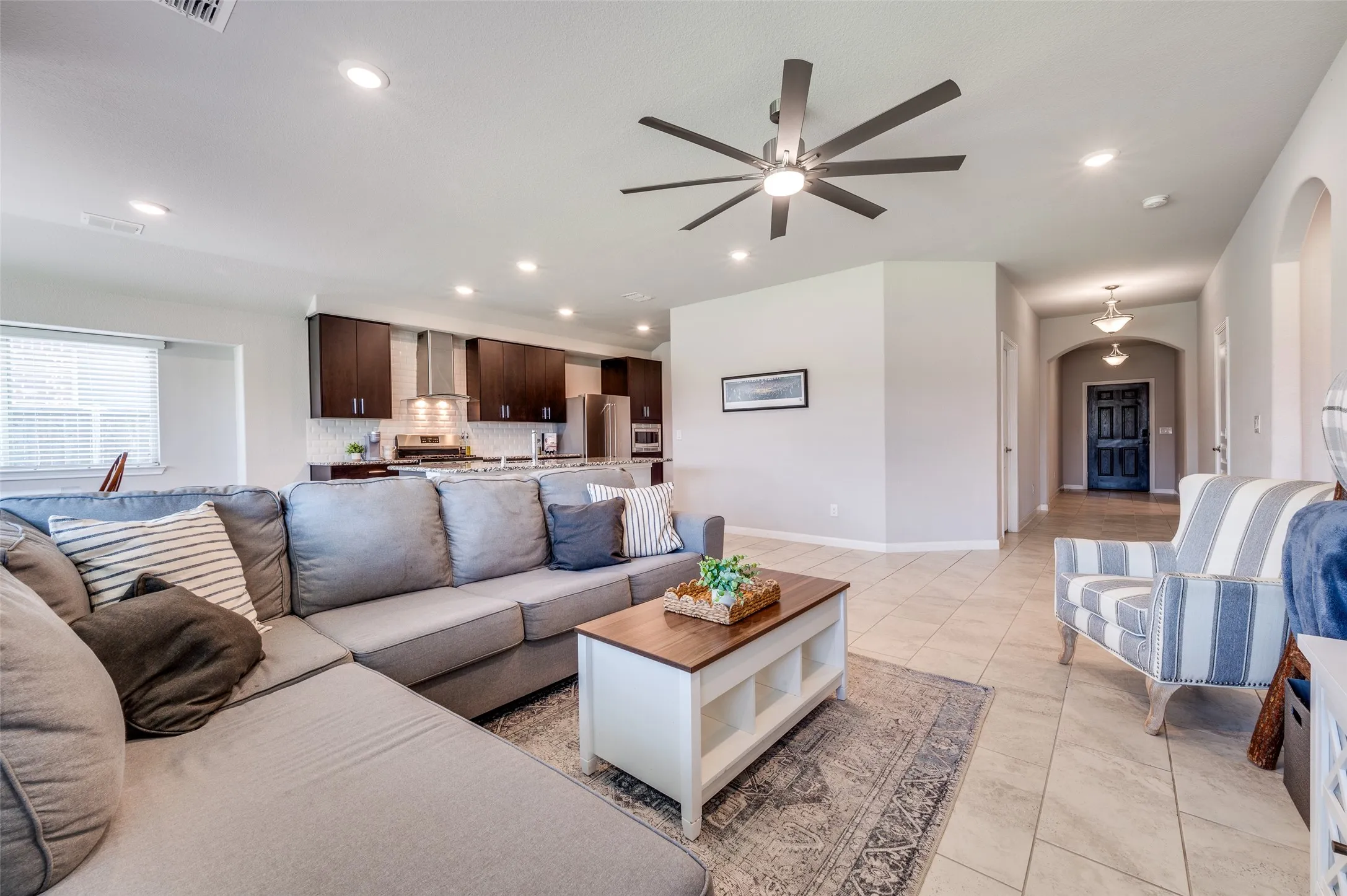 Open-concept living space featuring recessed lighting, a modern ceiling fan, and tile flooring