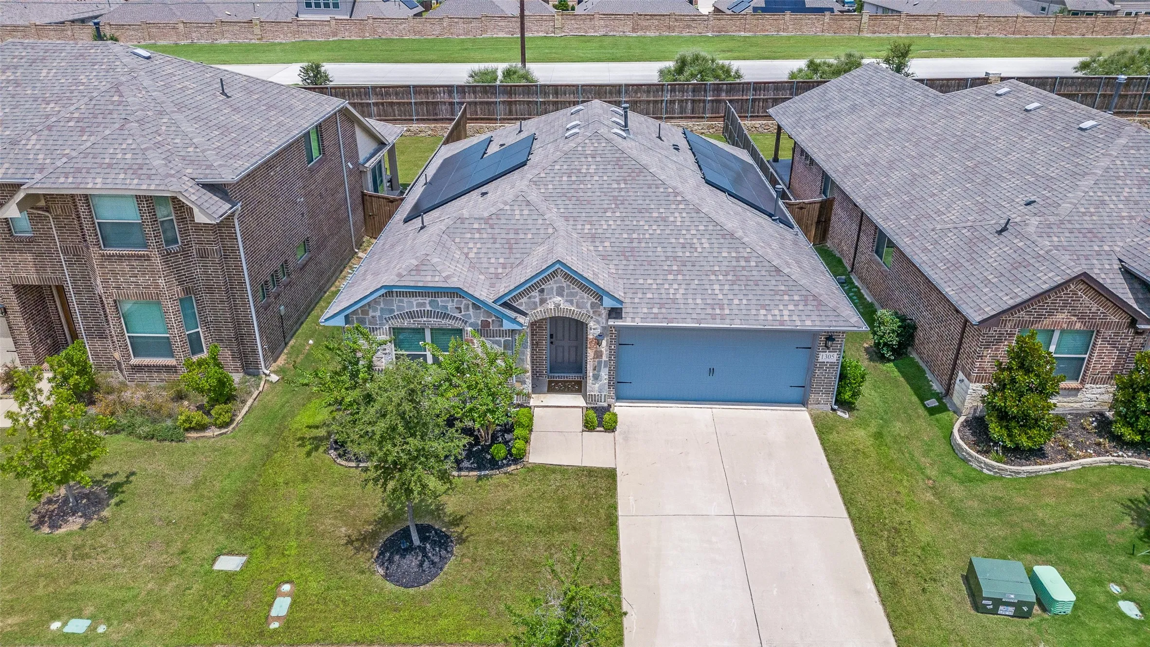 Single-story residence featuring a brick and stone facade, a two-car garage, and a concrete driveway
