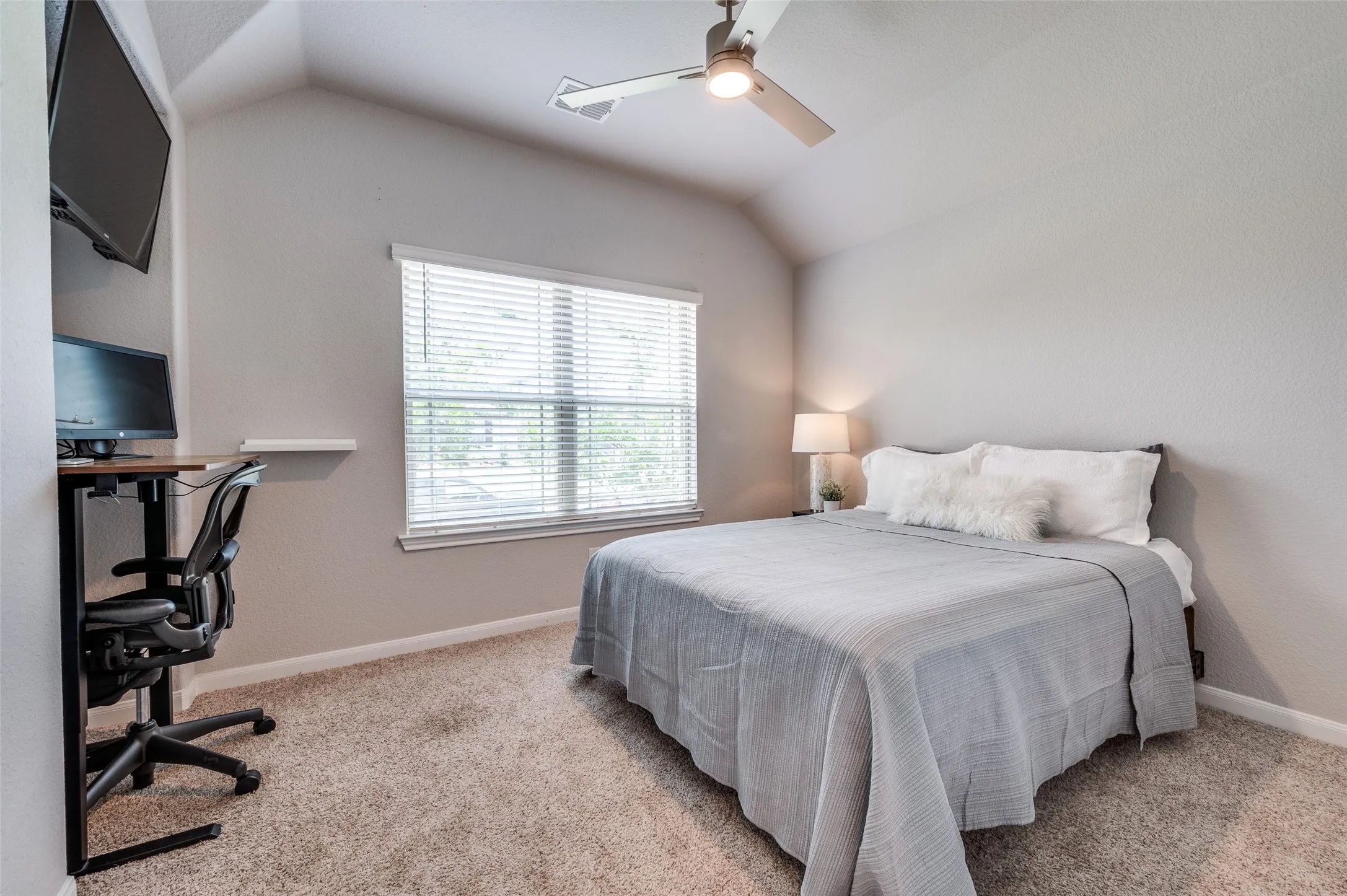 Vaulted ceiling with a ceiling fan, carpeted flooring, window with blinds, and neutral wall tones