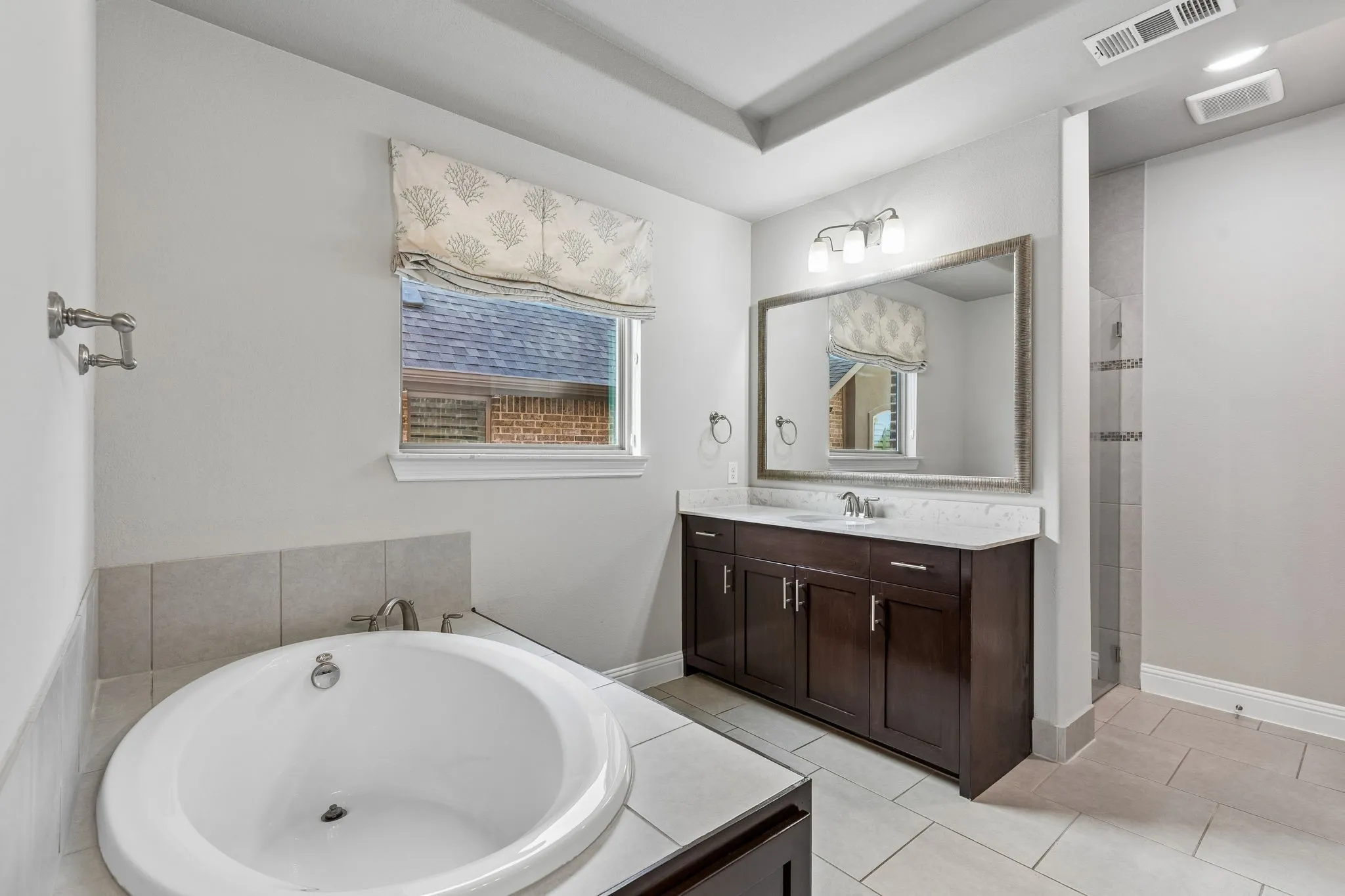 The spacious primary bath offers dual vanities, a garden tub and separate walk-in shower for a comfortable retreat.