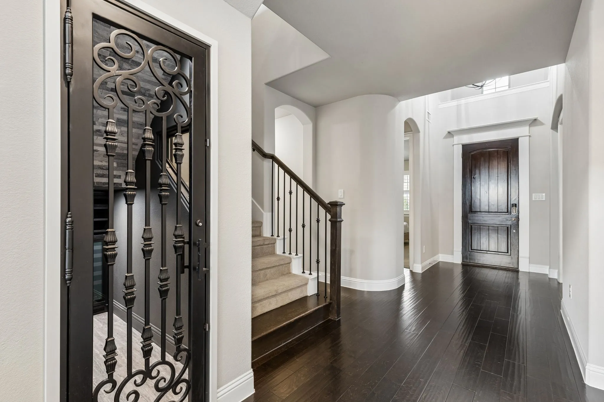 A custom wrought iron door welcomes you to your own 251+ bottle wine cellar