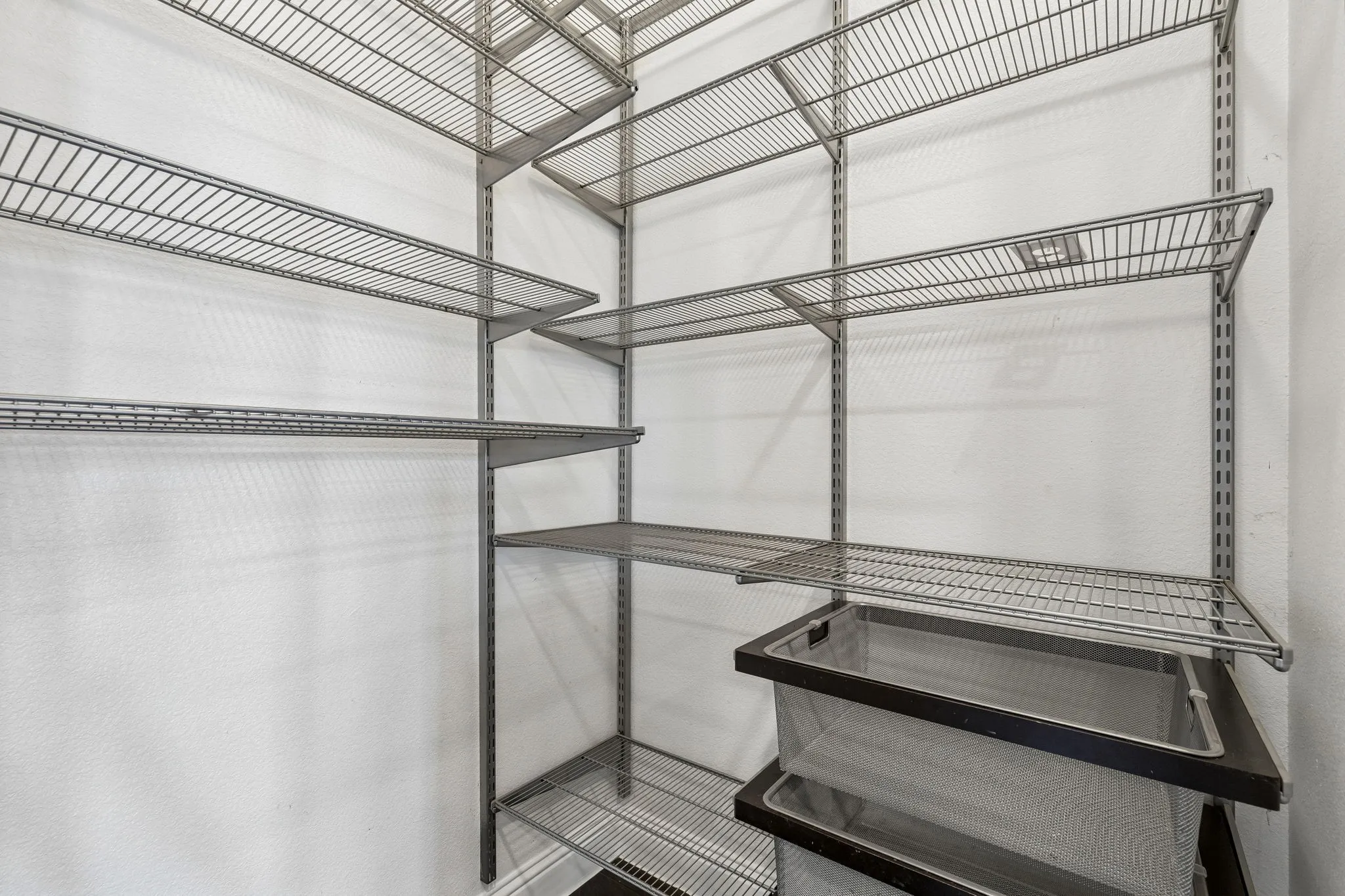 The walk-in pantry is outfitted with an Elfa storage system, providing abundant adjustable shelving and organized storage.