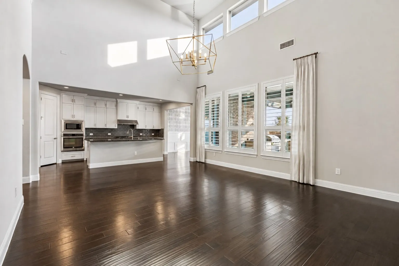 At the heart of the home, a wall of 2-story windows captures incredible Texas sunsets and fills the open-concept living space with natural light