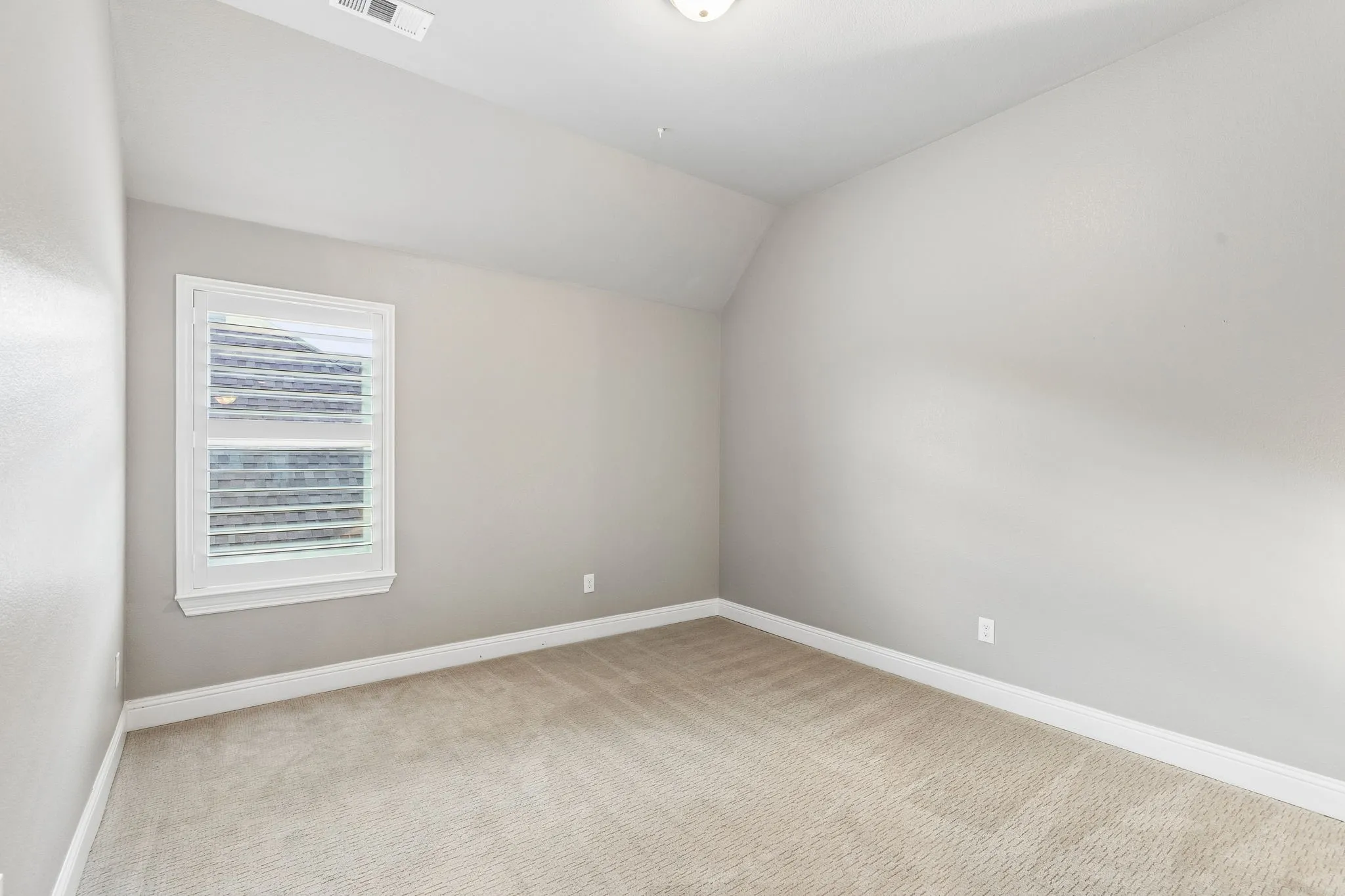 secondary bedroom features recently installed carpet, plantation shutters and a neutral palette ready for personalization.