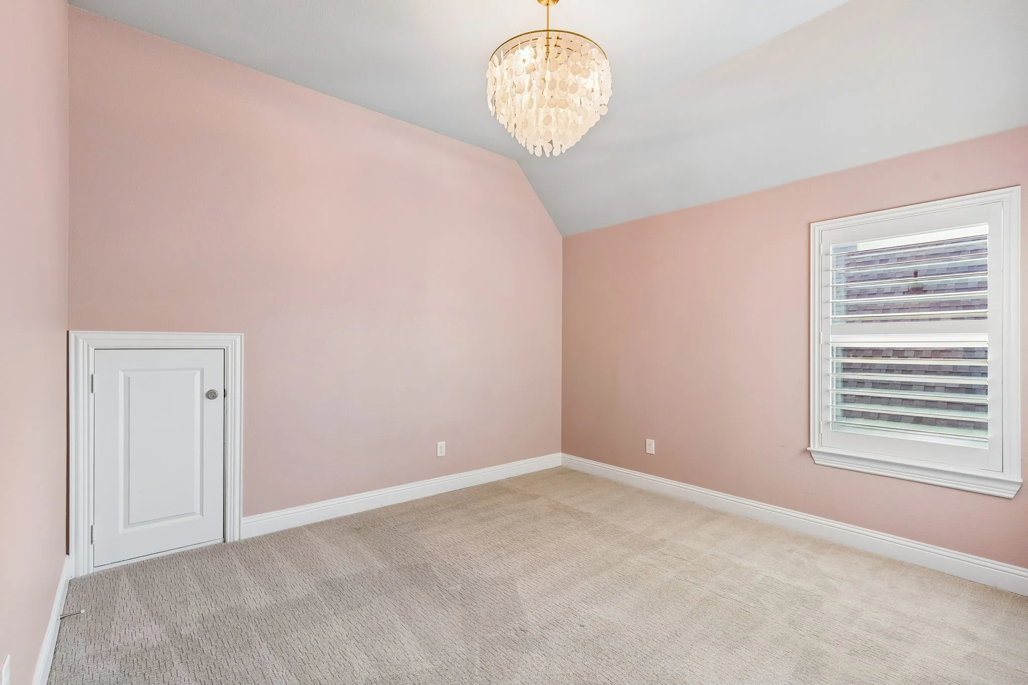Vaulted ceilings, plantation shutters and a designer light fixture add character to this upstairs secondary bedroom.