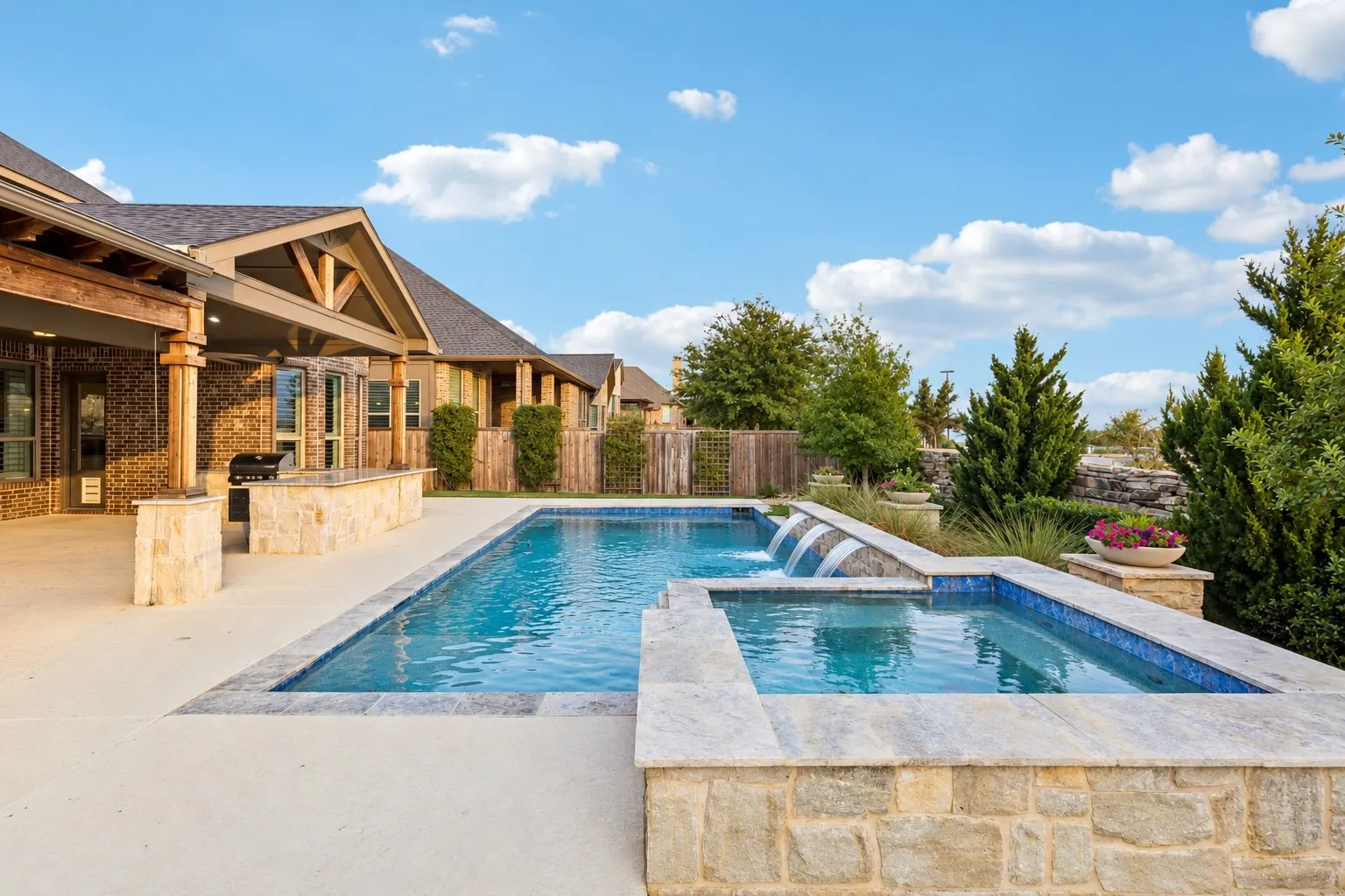 The heated saltwater pool and attached spa feature sheer-descent water elements and are surrounded by thoughtfully designed outdoor living spaces and mature landscaping