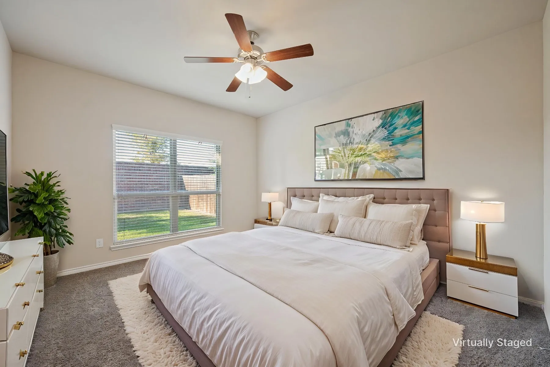 Neutral-toned walls complementing a textured headboard, ceiling fan with light fixture, window with blinds, and carpeting