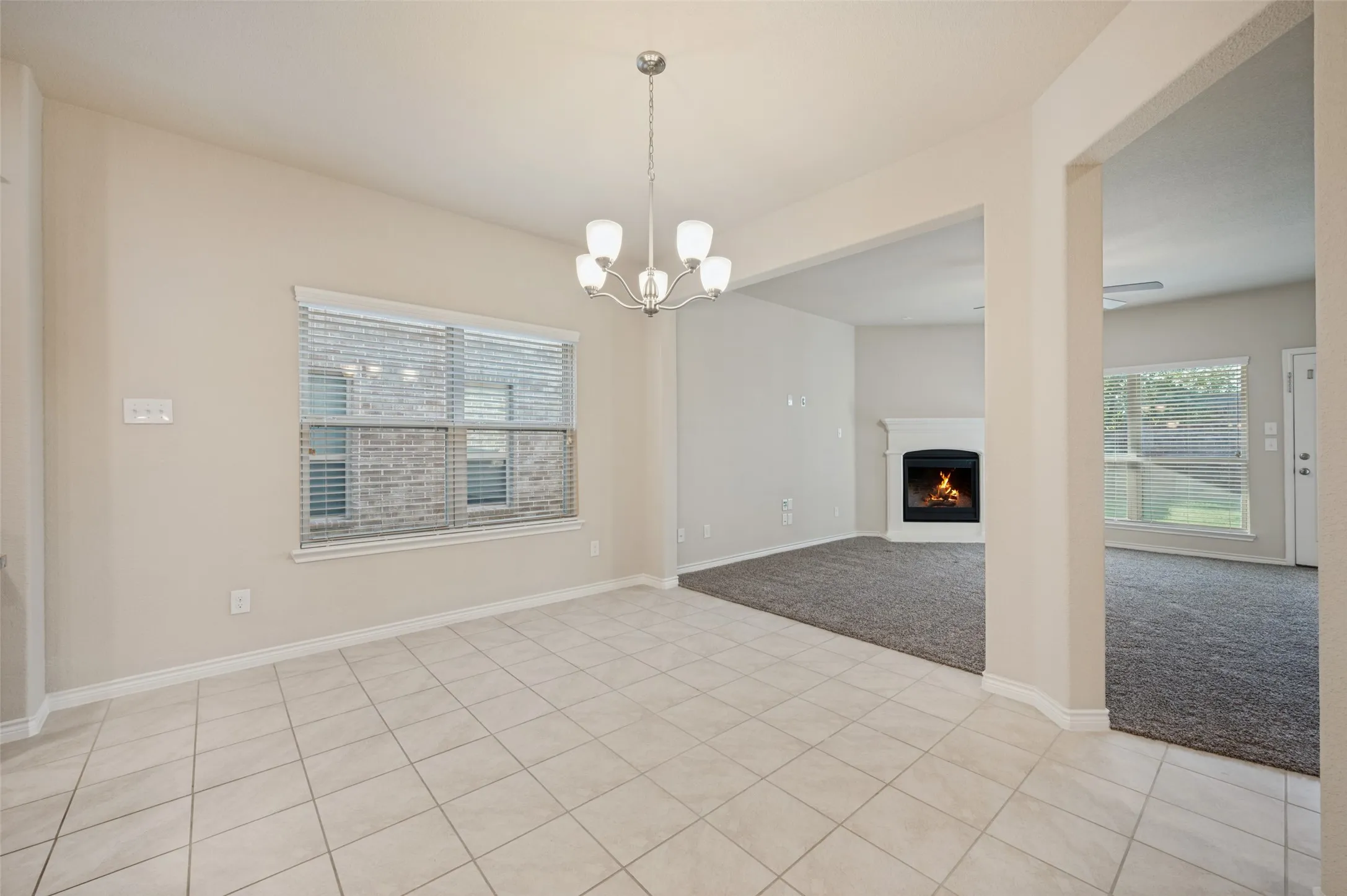 Tile flooring, built-in fireplace, natural light, and a modern chandelier